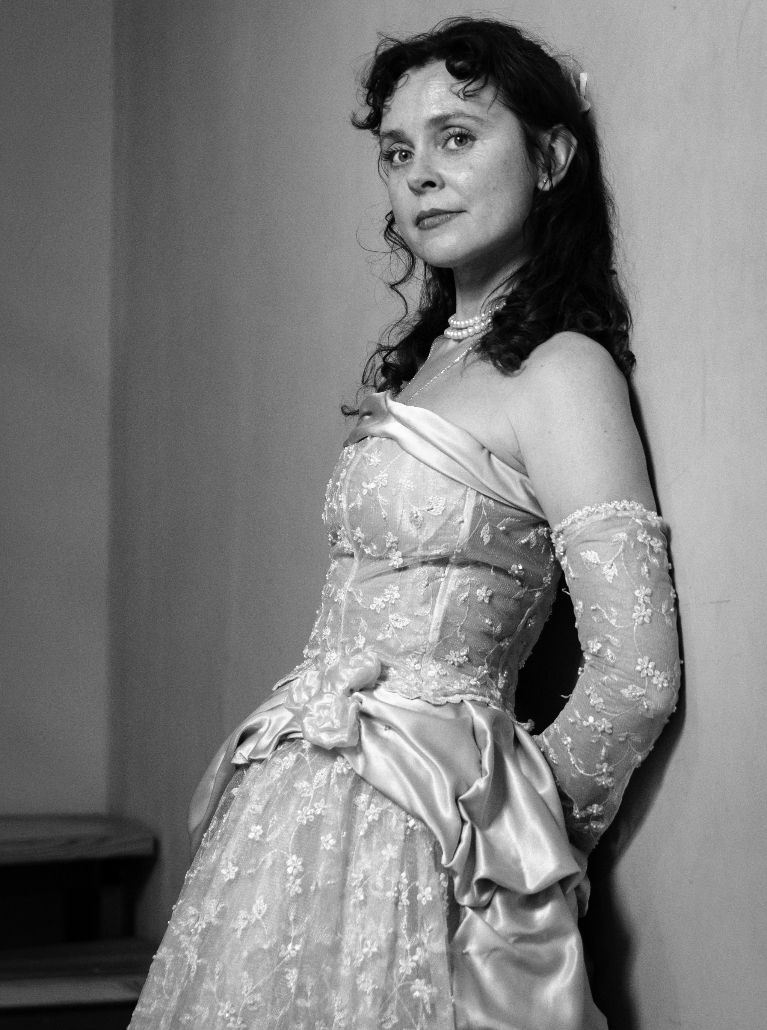 черно белый портрет женщины в вечернем платье у стены