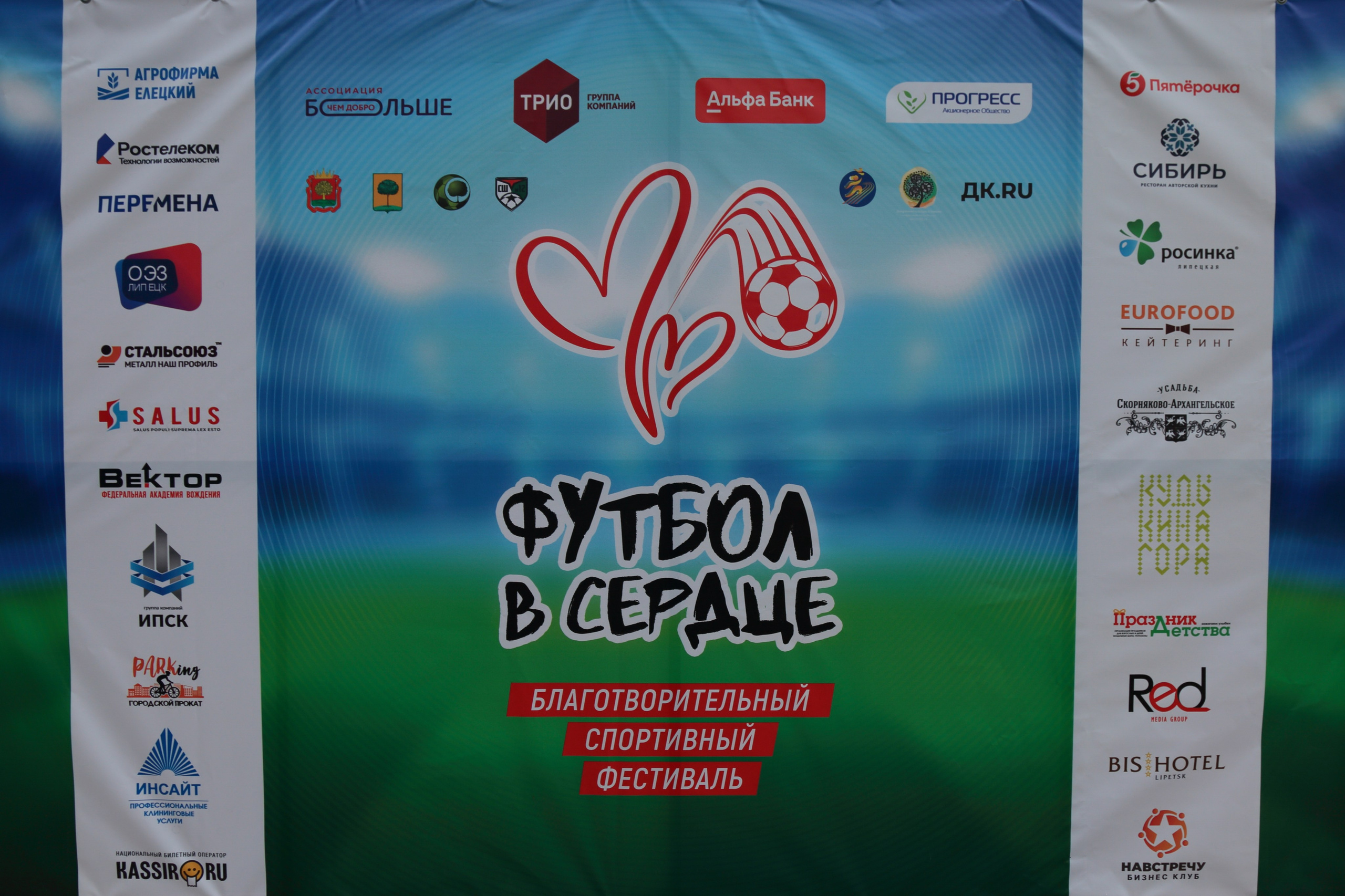 Яркая фотография баннера фестиваля «Футбол в сердце» на стадионе в Липецке.