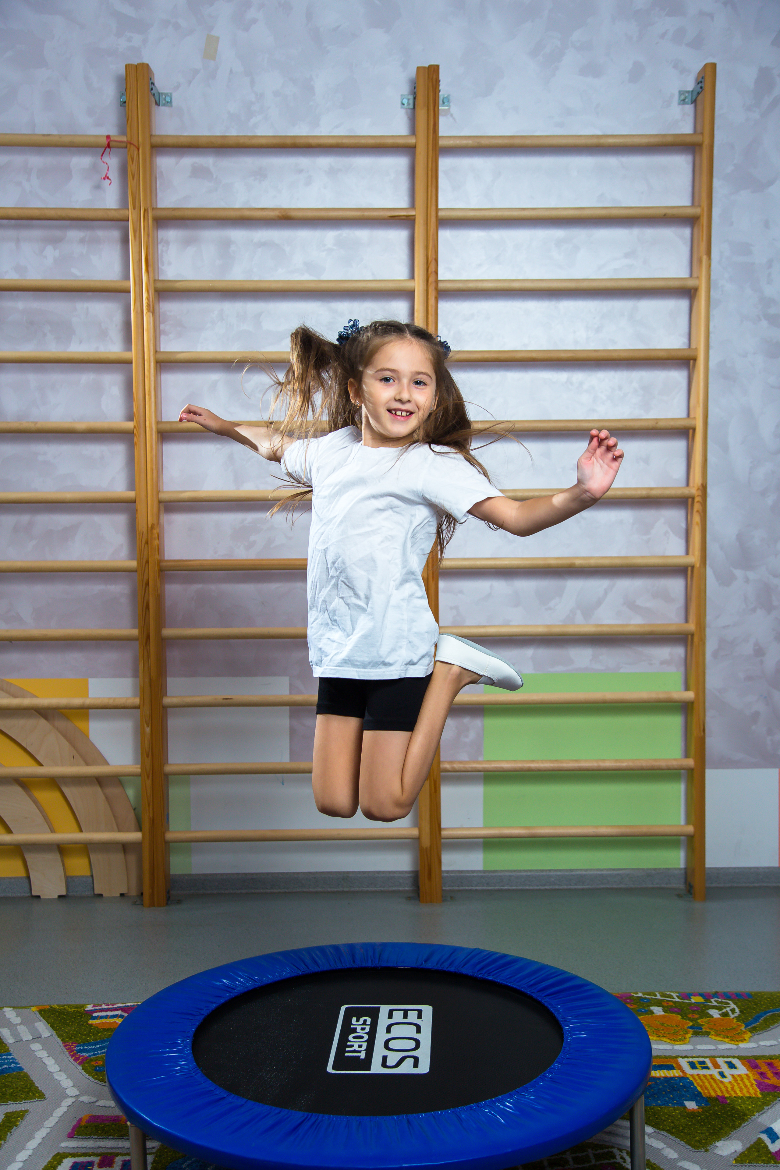 девочка прыгает на батуте в садике