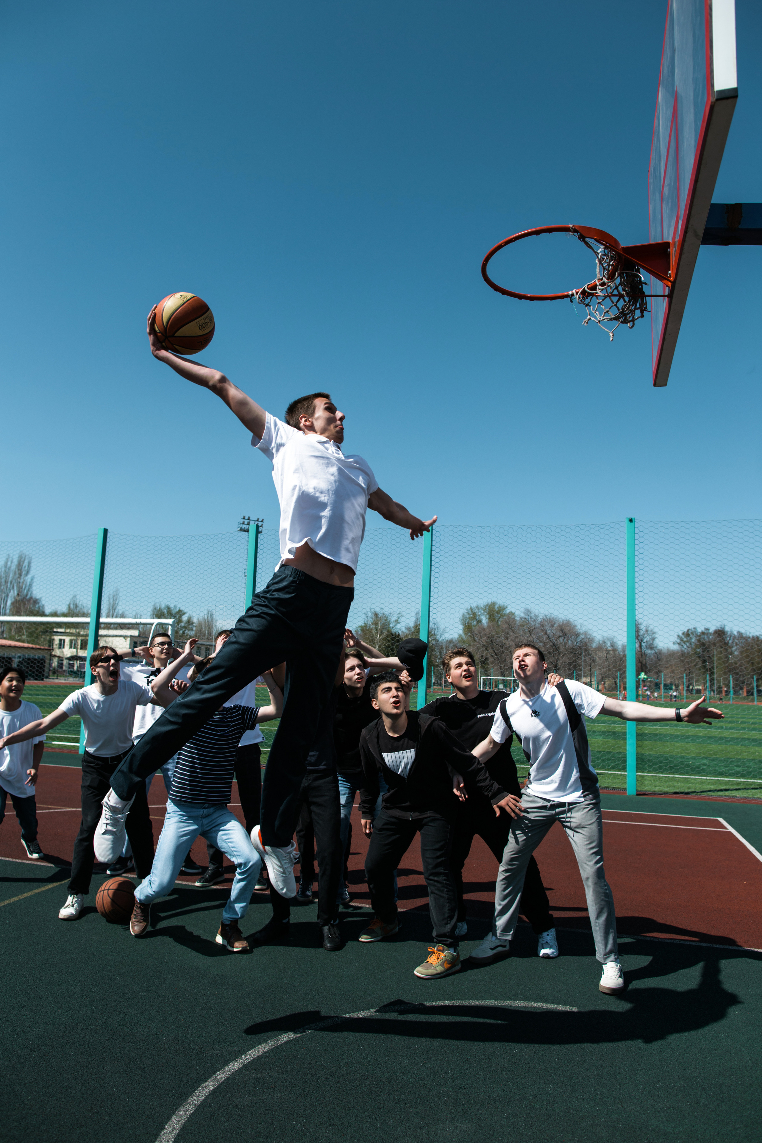 парень забивает мяч в кольцо