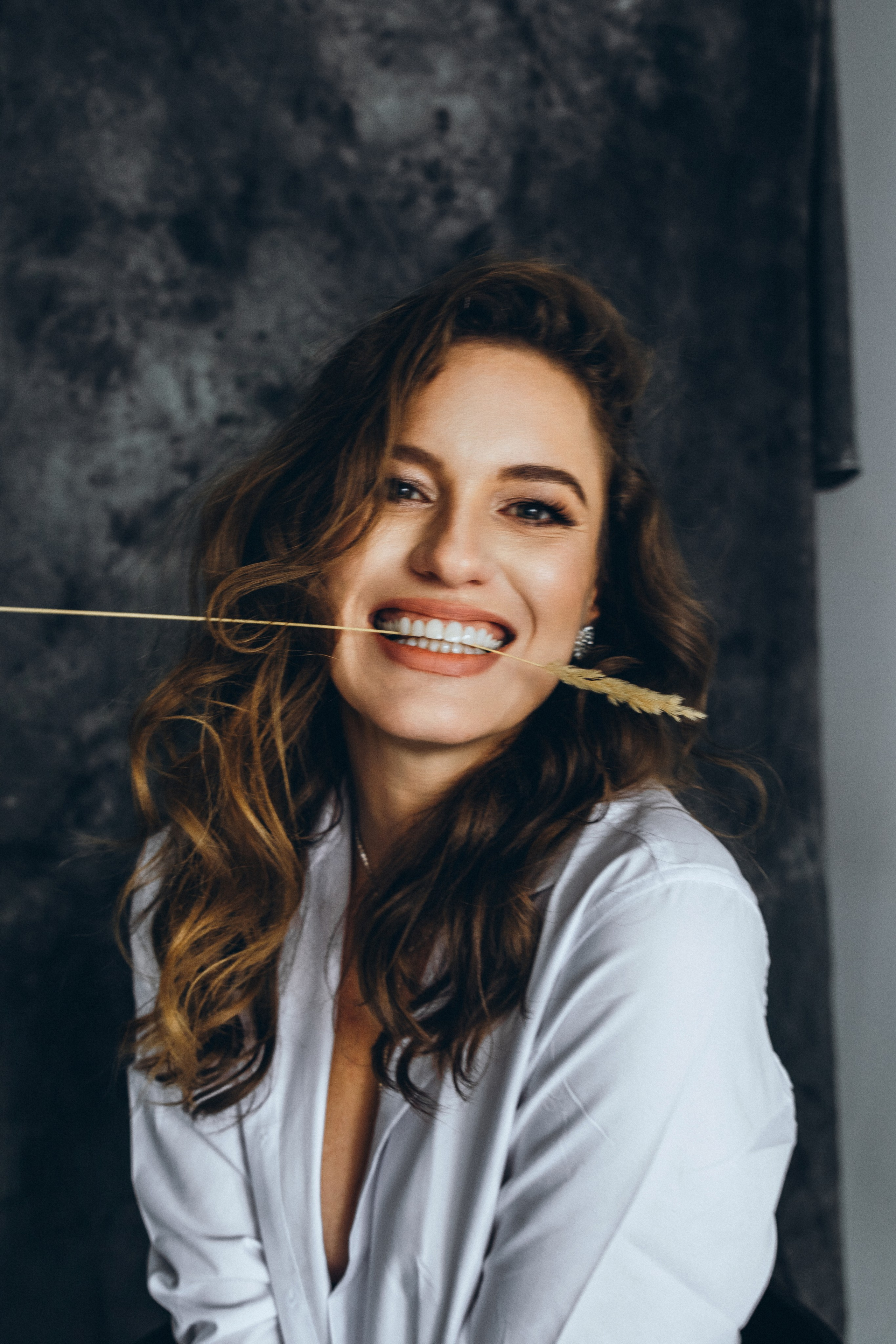 красивая девушка широко улыбается в белой рубашке