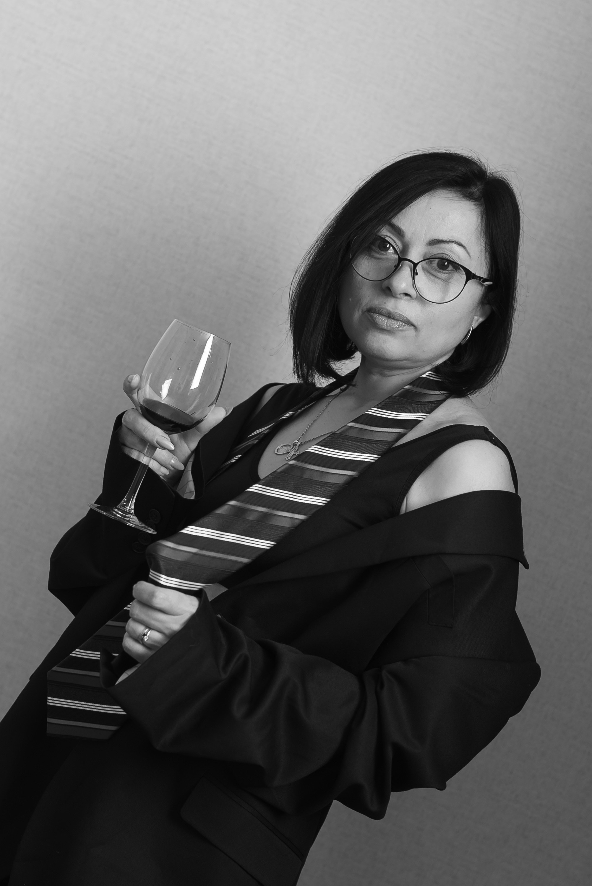 Девушка в черном костюме с галстуком.