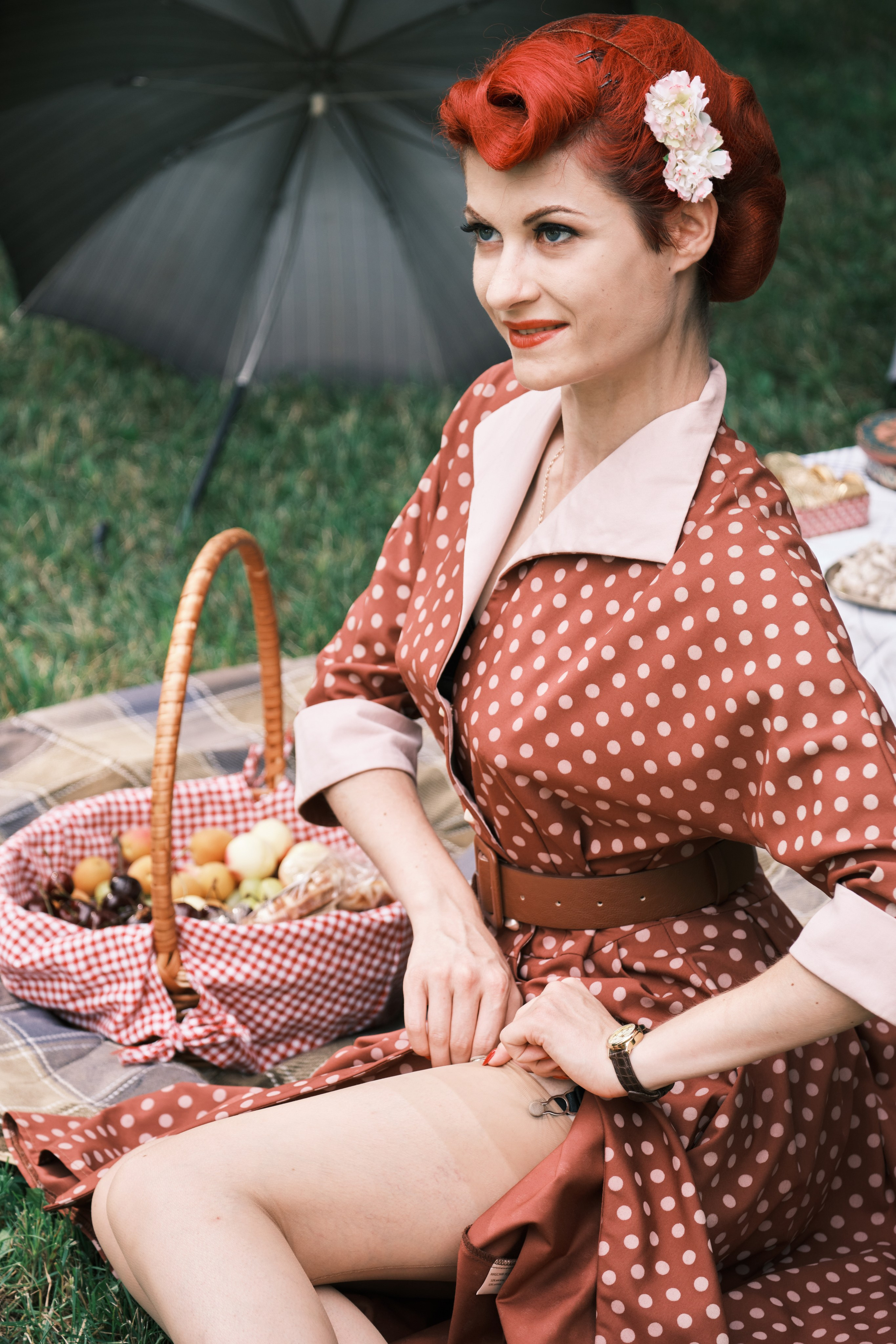 Девушка сидит на покрывале поправля колготки 