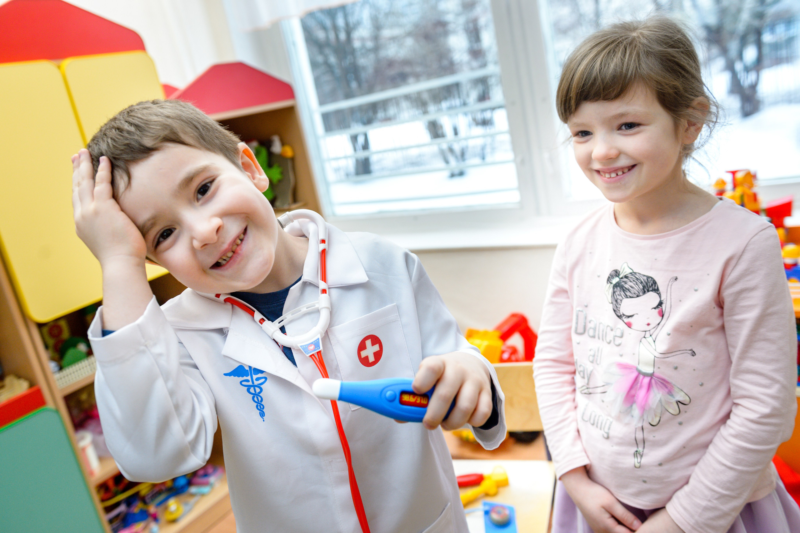 Мальчик и девочка в детском саду играют в доктора и пациента. 