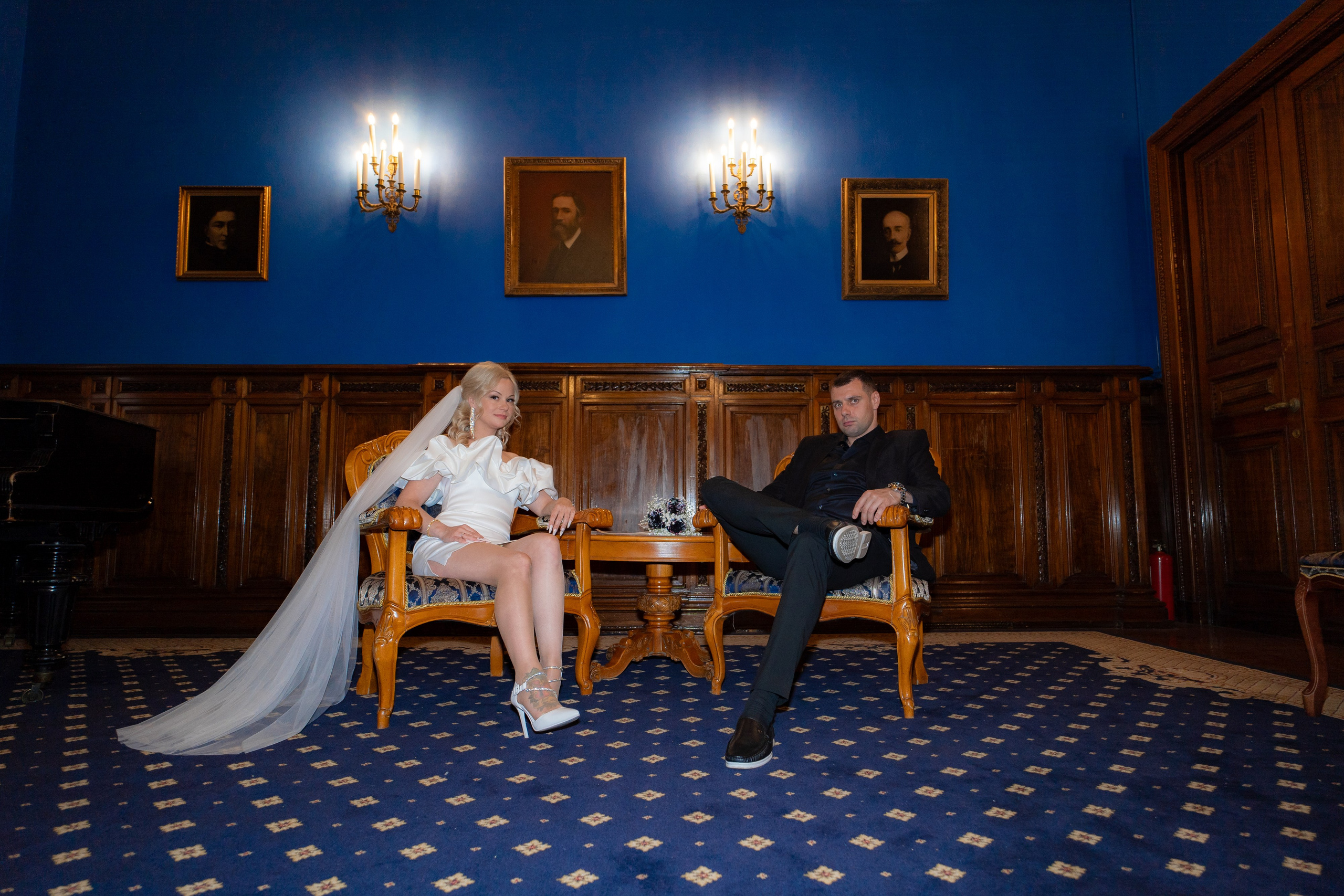 жених и невеста сидят в синем зале дворца бракосочетания №1 на коричневых старинных креслах