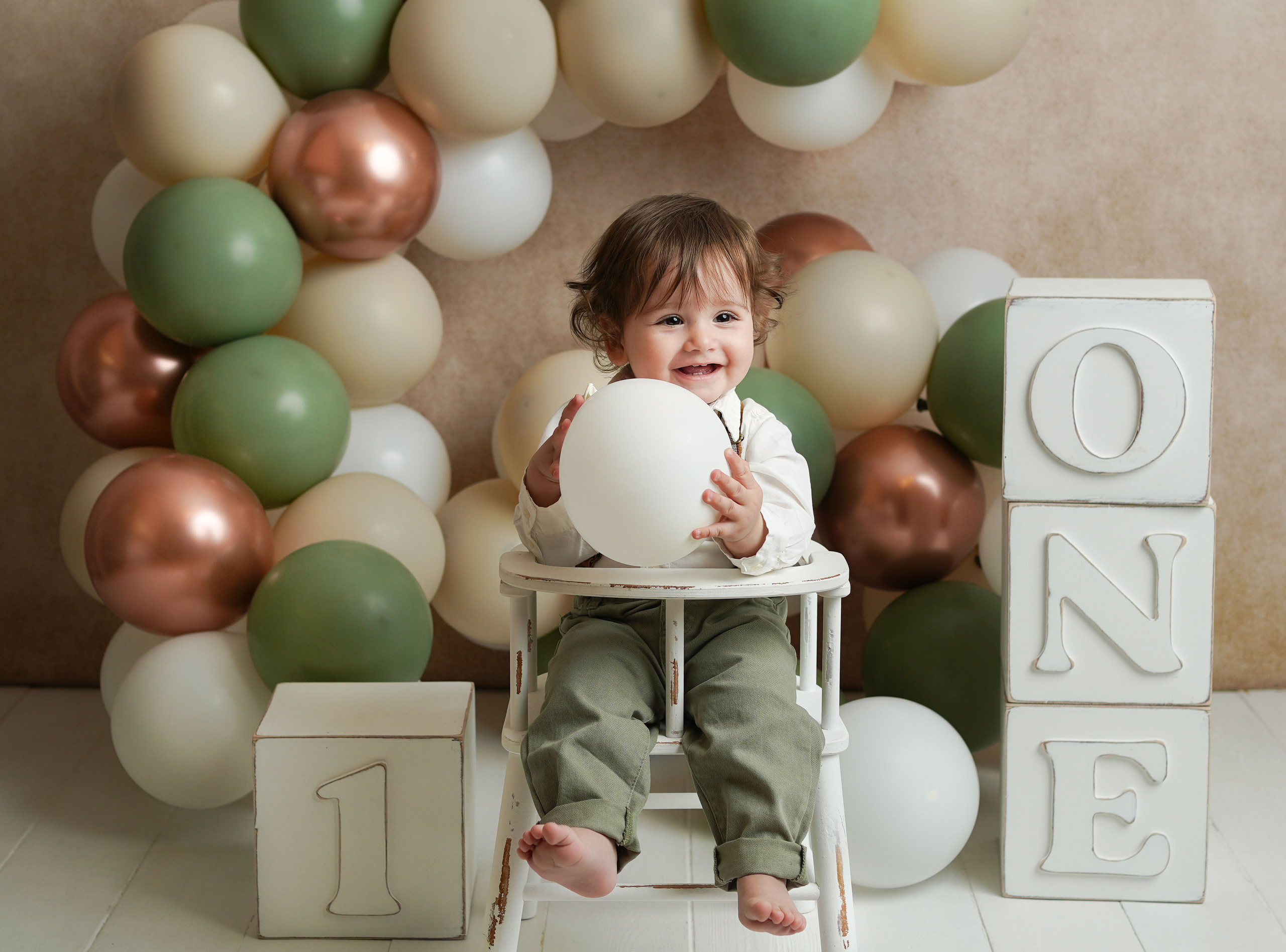 Малыш на фотосессии Первый годик был очень улыбчивый и довольный , сфотографирован на детском стульчике рядом с кубиками год.