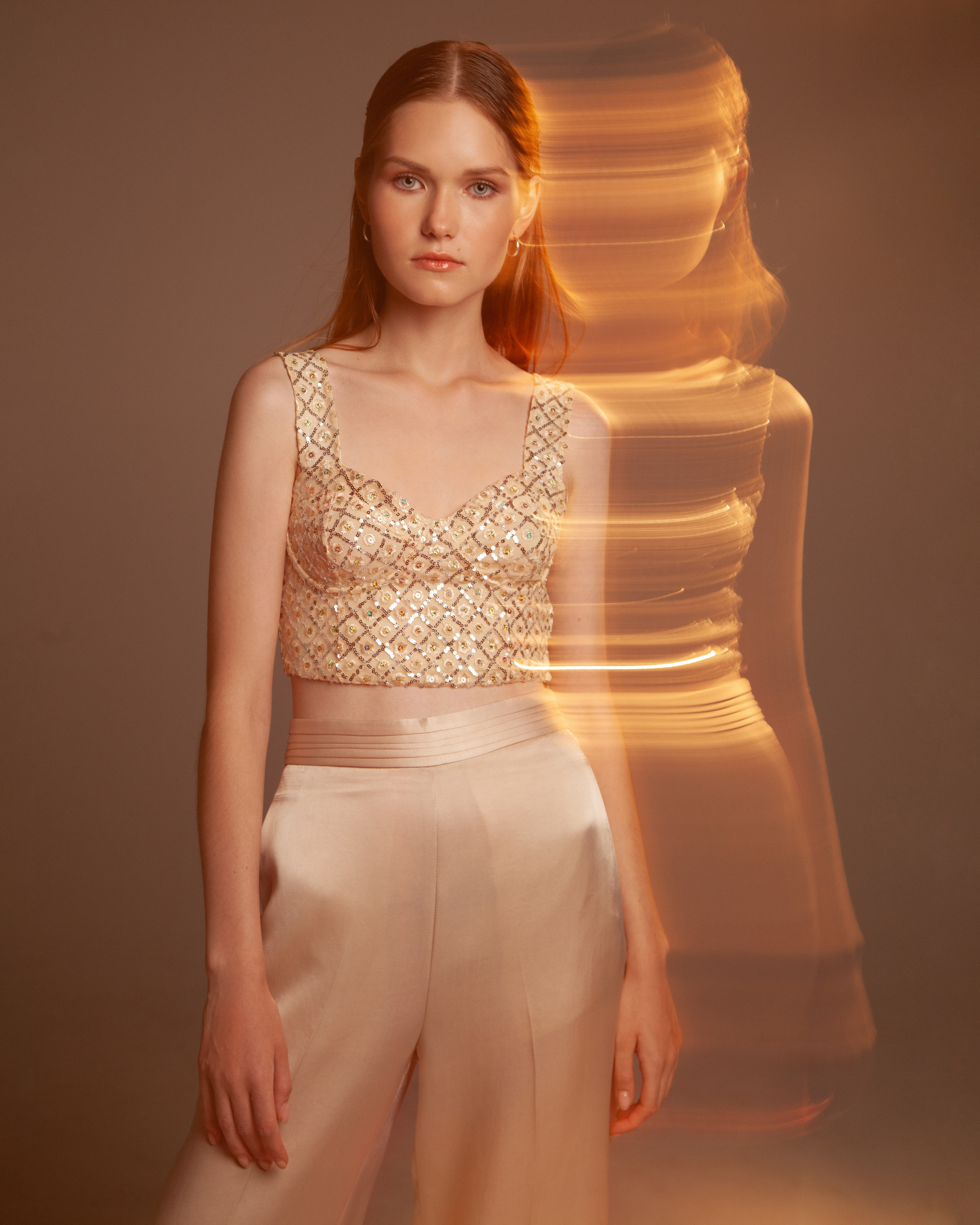 Новогодний образ девушки в топе со стразами и шелковых брюках на фотосессию.