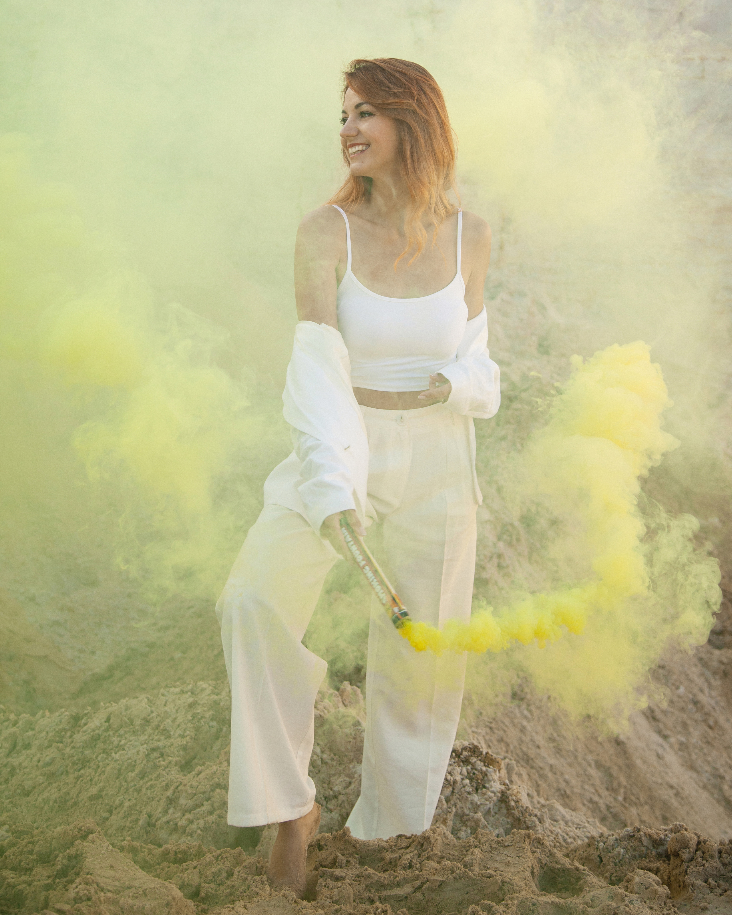 Молодая девушка держит в руке желтый дым