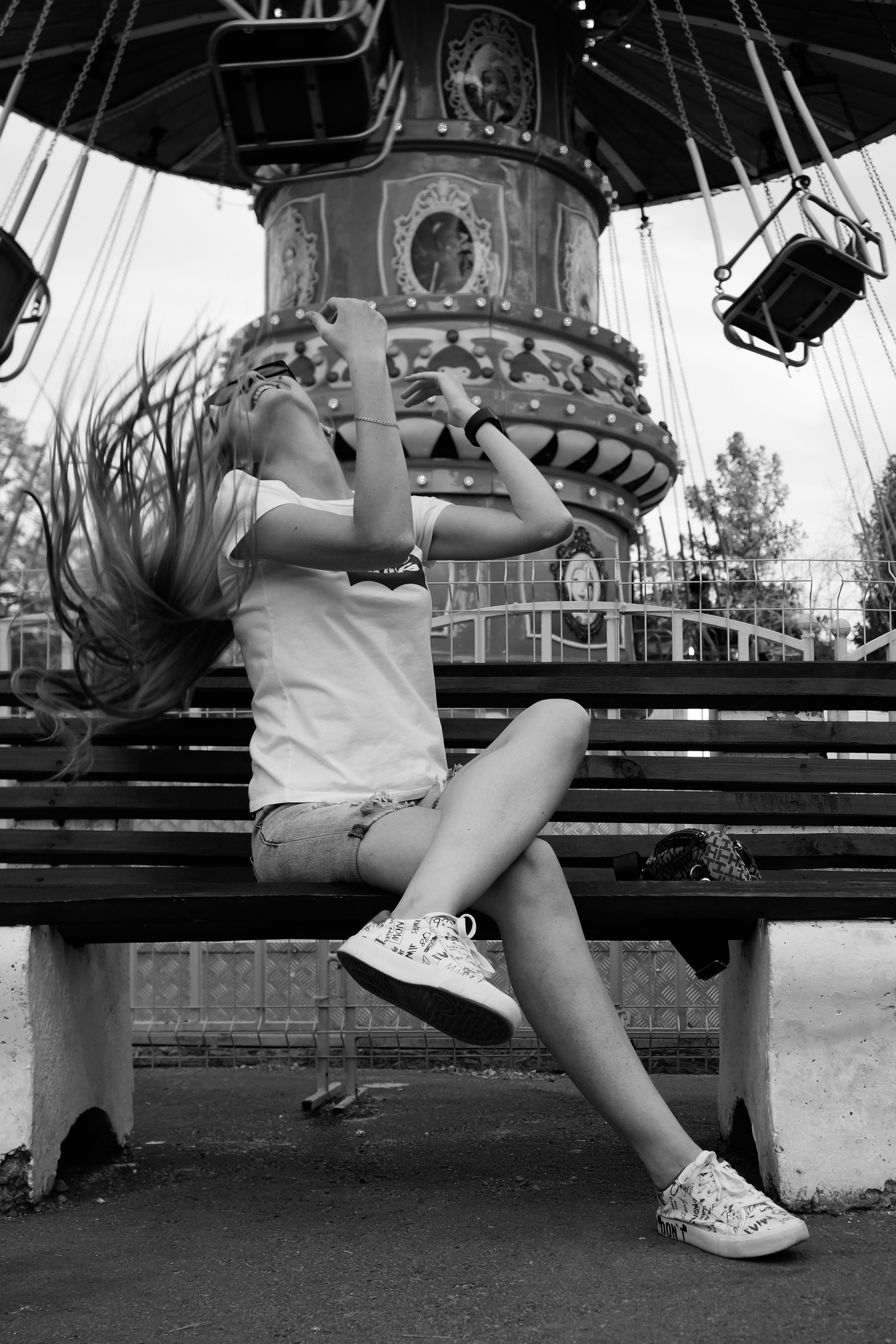 Фото девушки в парке на фоне карусели