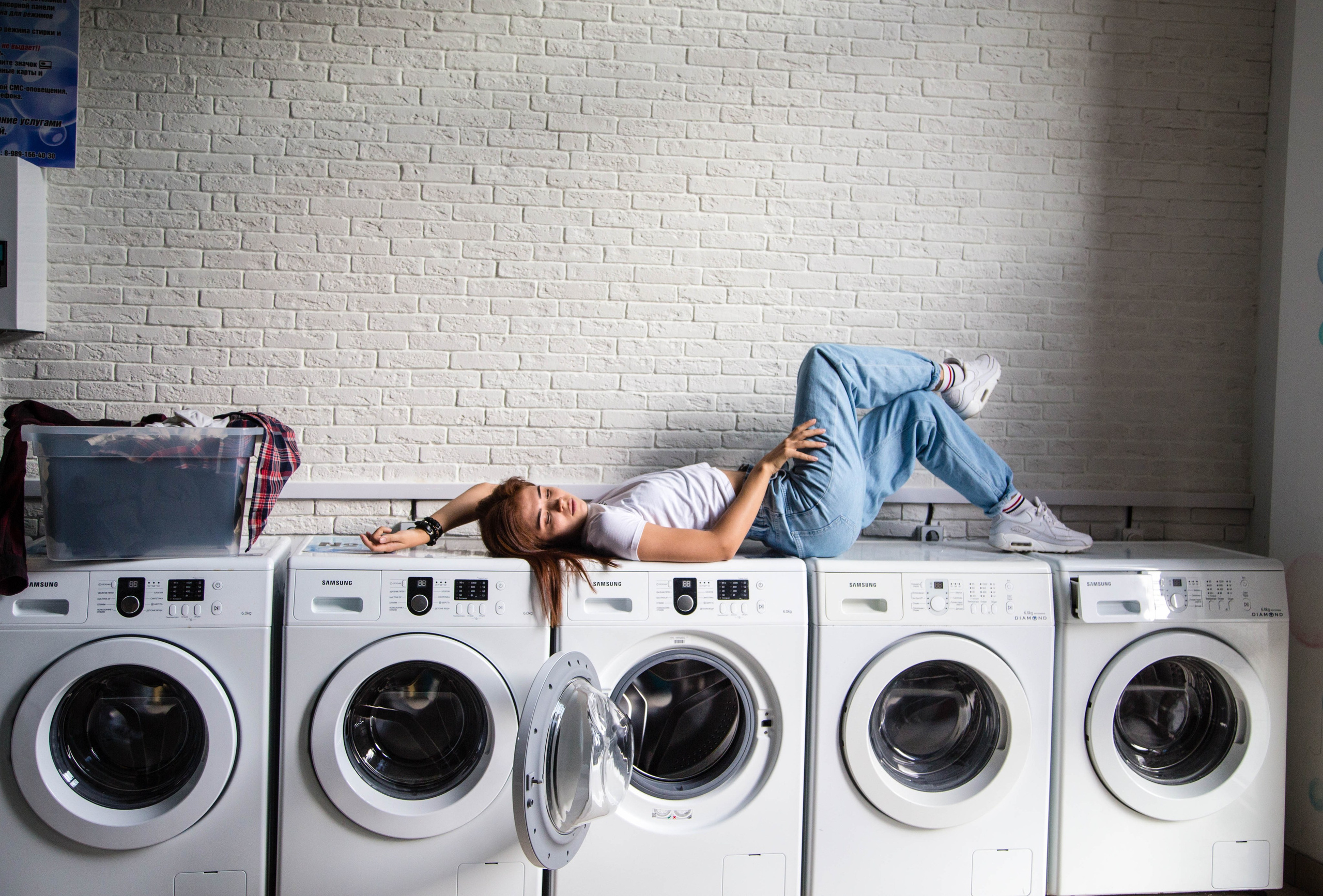 Девушка лежит на стиральной машинке 