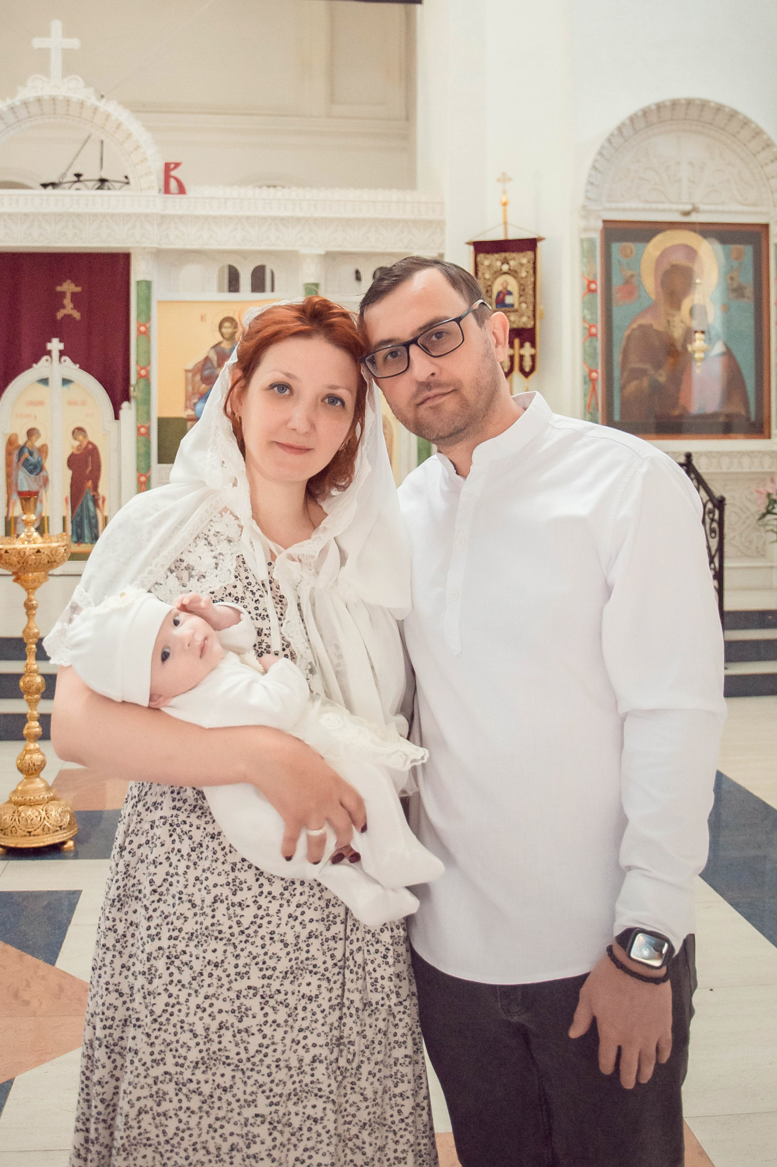 Семейный портрет родителей с дочкой в храме.