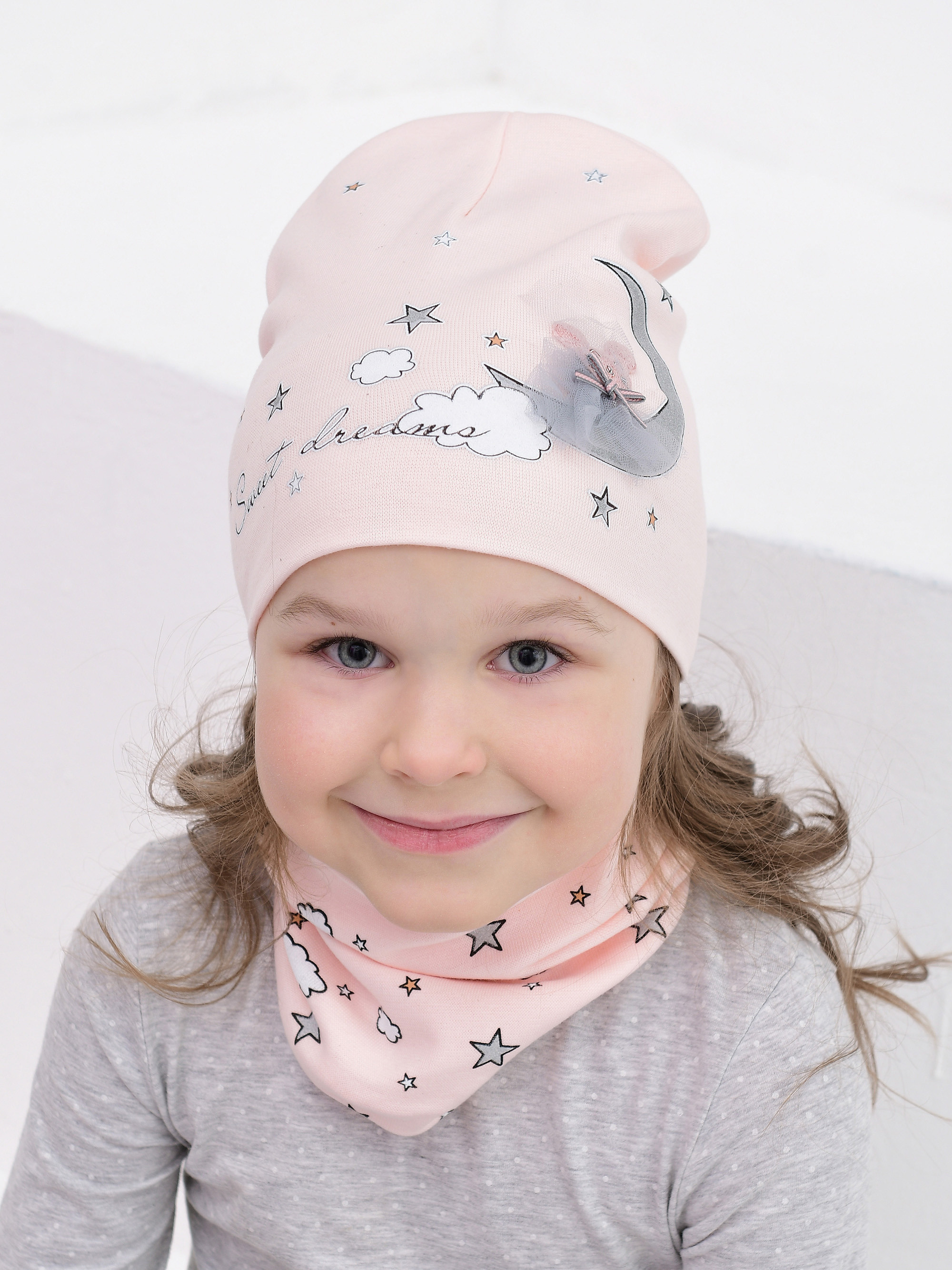 Модель в детской шапке в студии во время съёмки шапок для интернет-магазина.