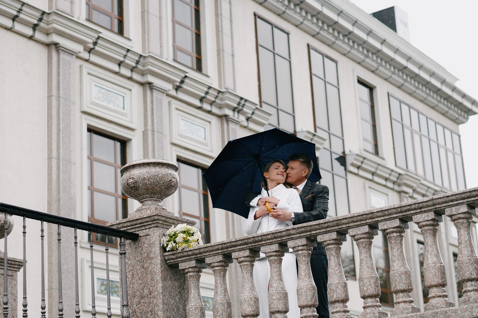 Свадебная пара Дмитрий и Мария под синим зонтом на фоне современной архитектуры Тюмени