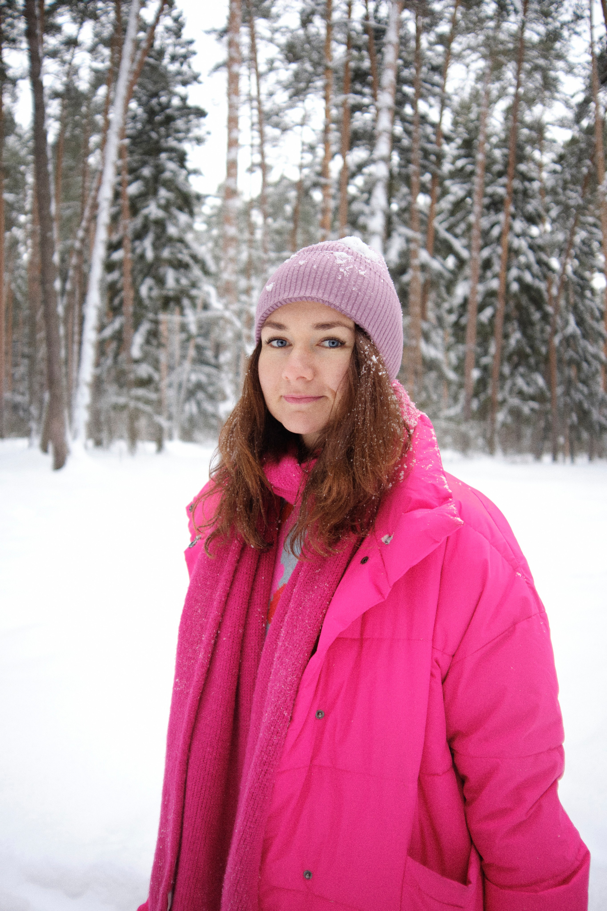 Женщина в яркой одежде в снежнем лесу