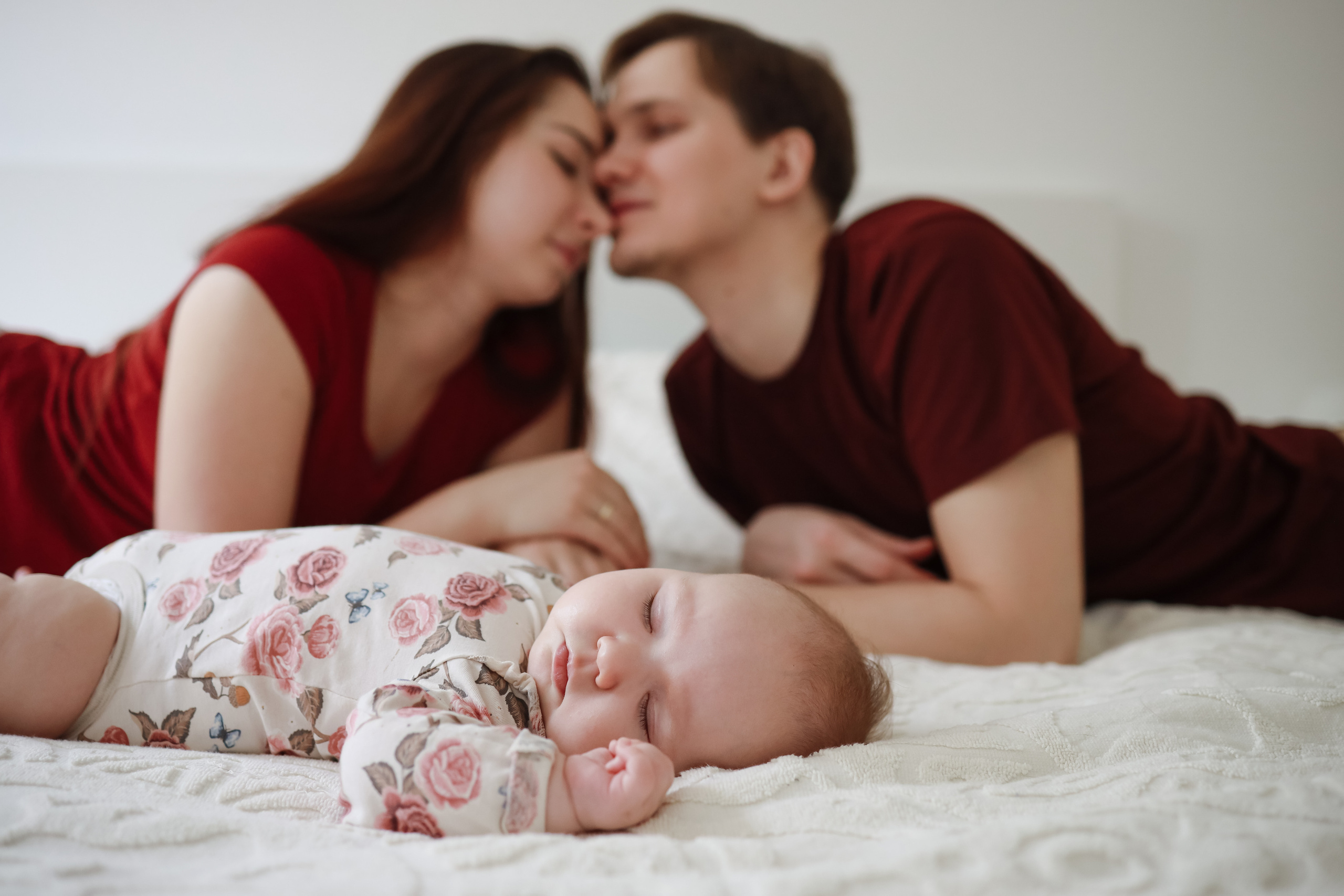 Папа целует маму пока младенец спит