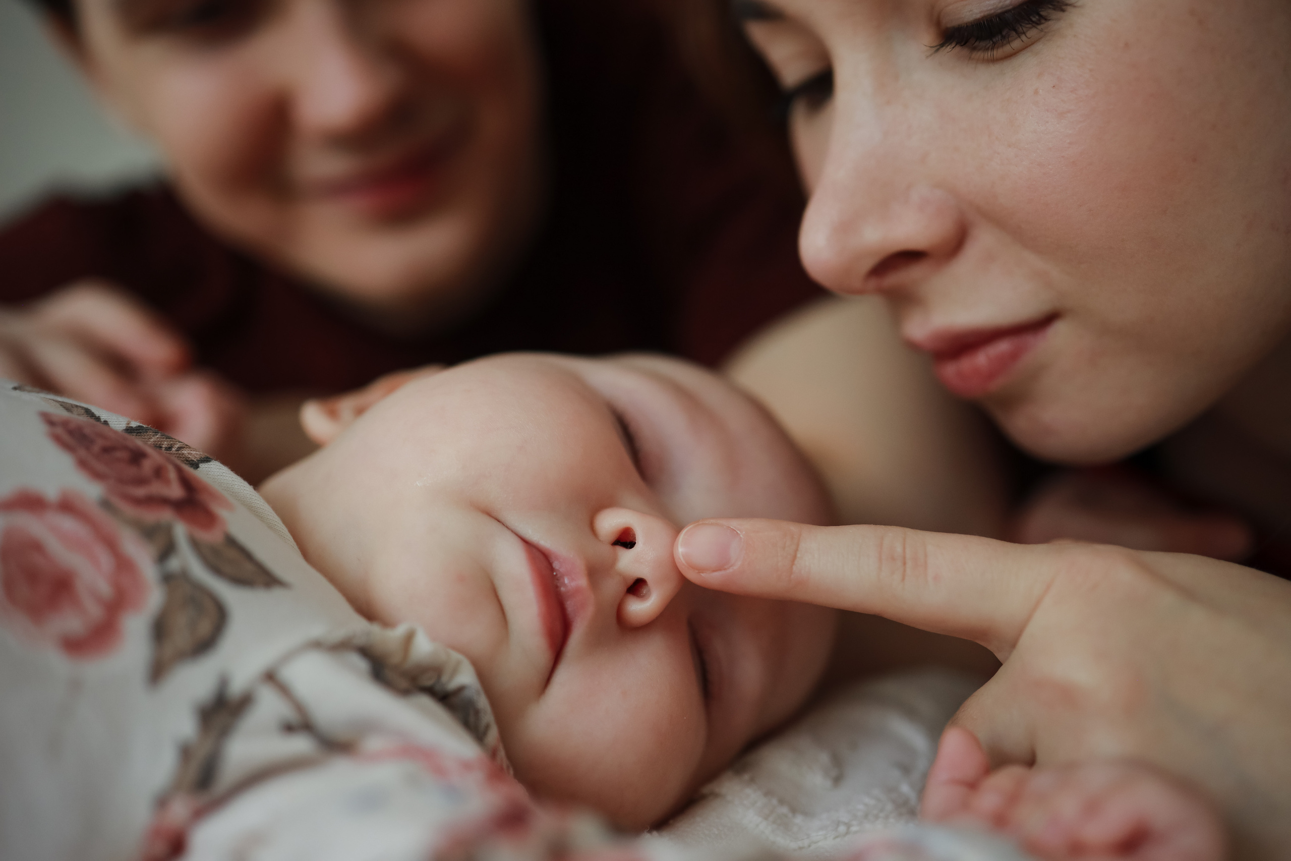 Крупный план мама трогает носик младенца