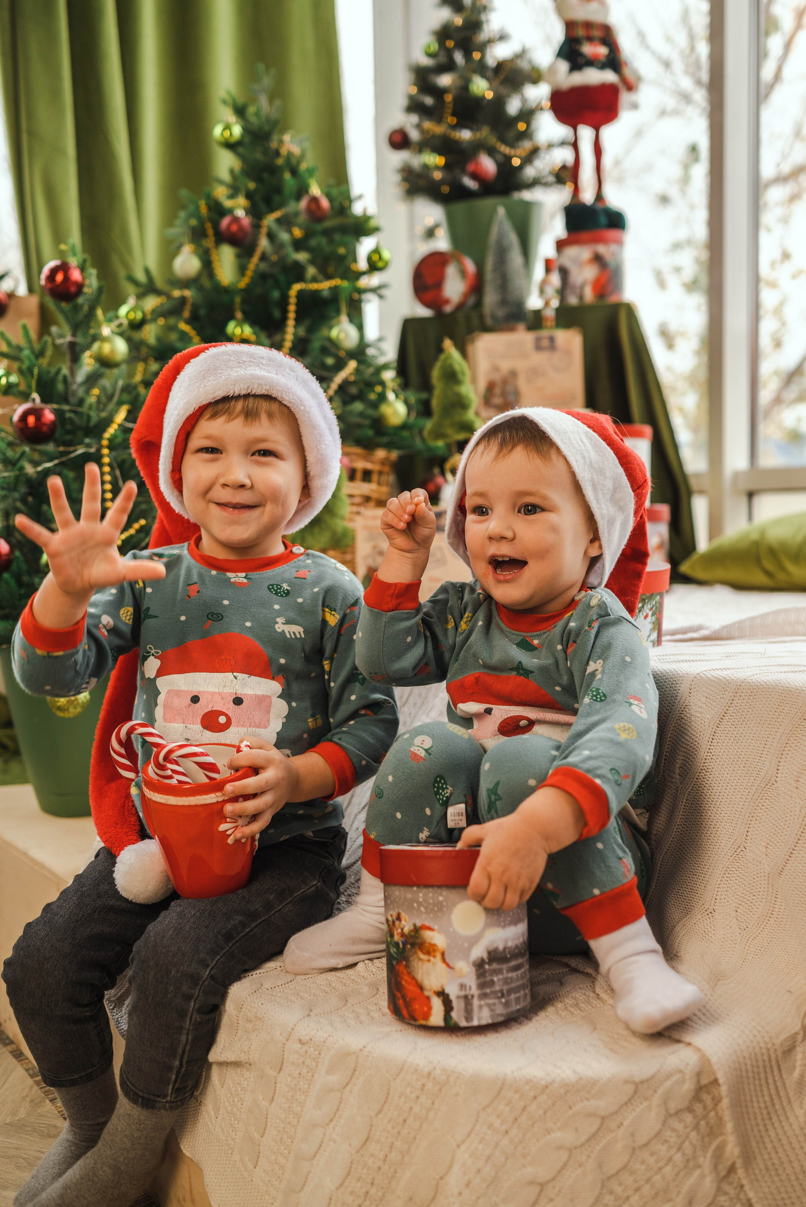 Детская семейная новогодняя фотосессия 2025 в фотостудии в Каменске-Шахтинском и Ростове-на-Дону. Двое маленьких детей сидят на фоне новогодней елки. Фотограф Ольга Сагал 