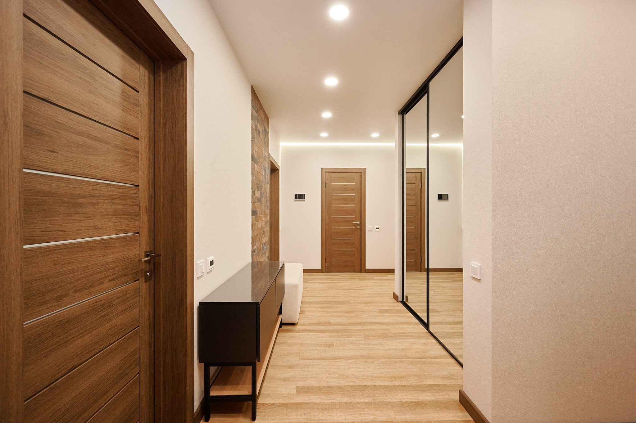 коридор со светлыми обоями и большим зеркальным шкафом купе 