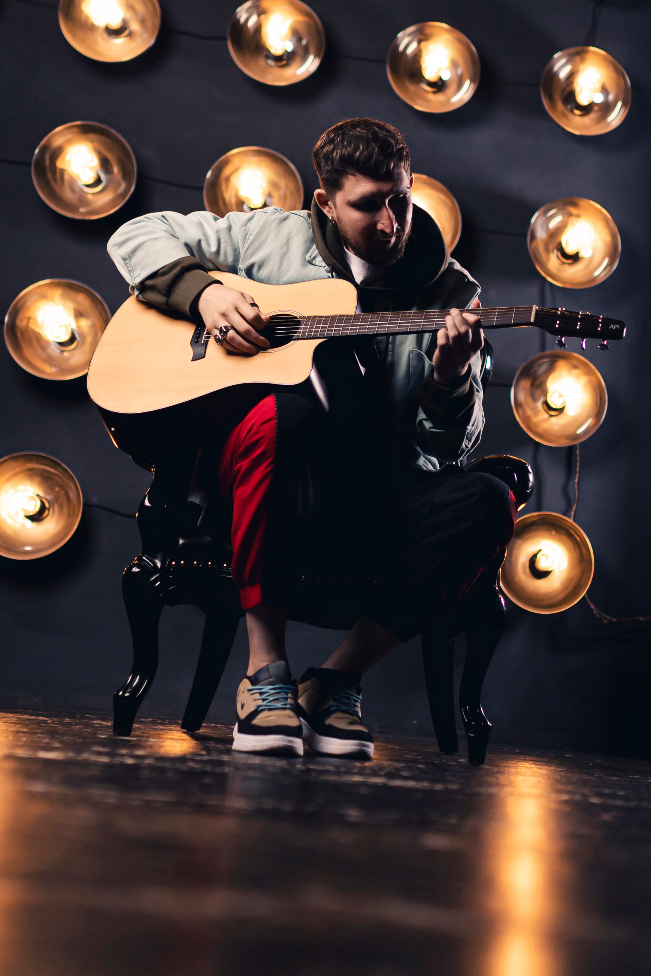 мужской портрет гитариста в студии 