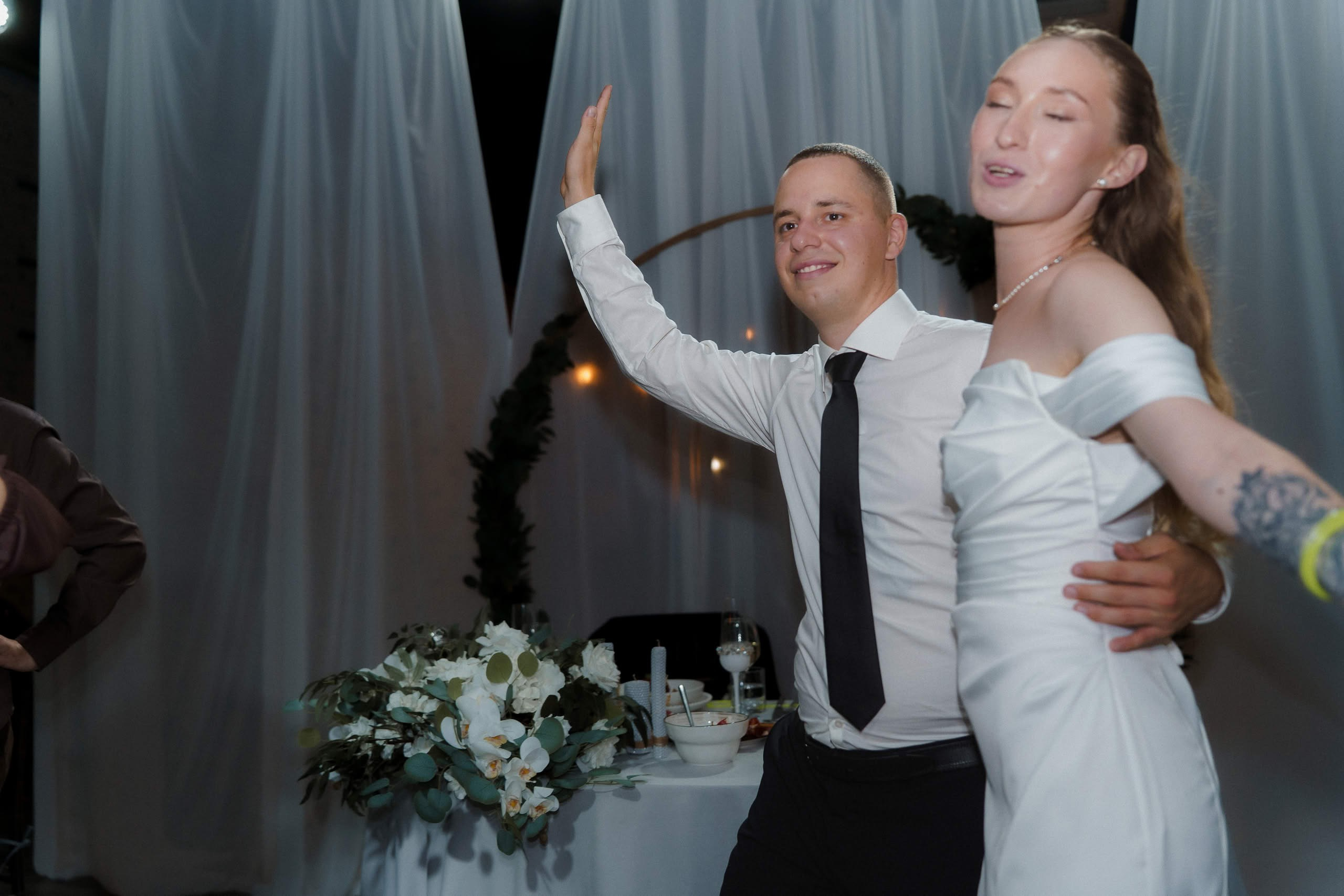 Невеста и жених танцуют и улыбаются на вечере