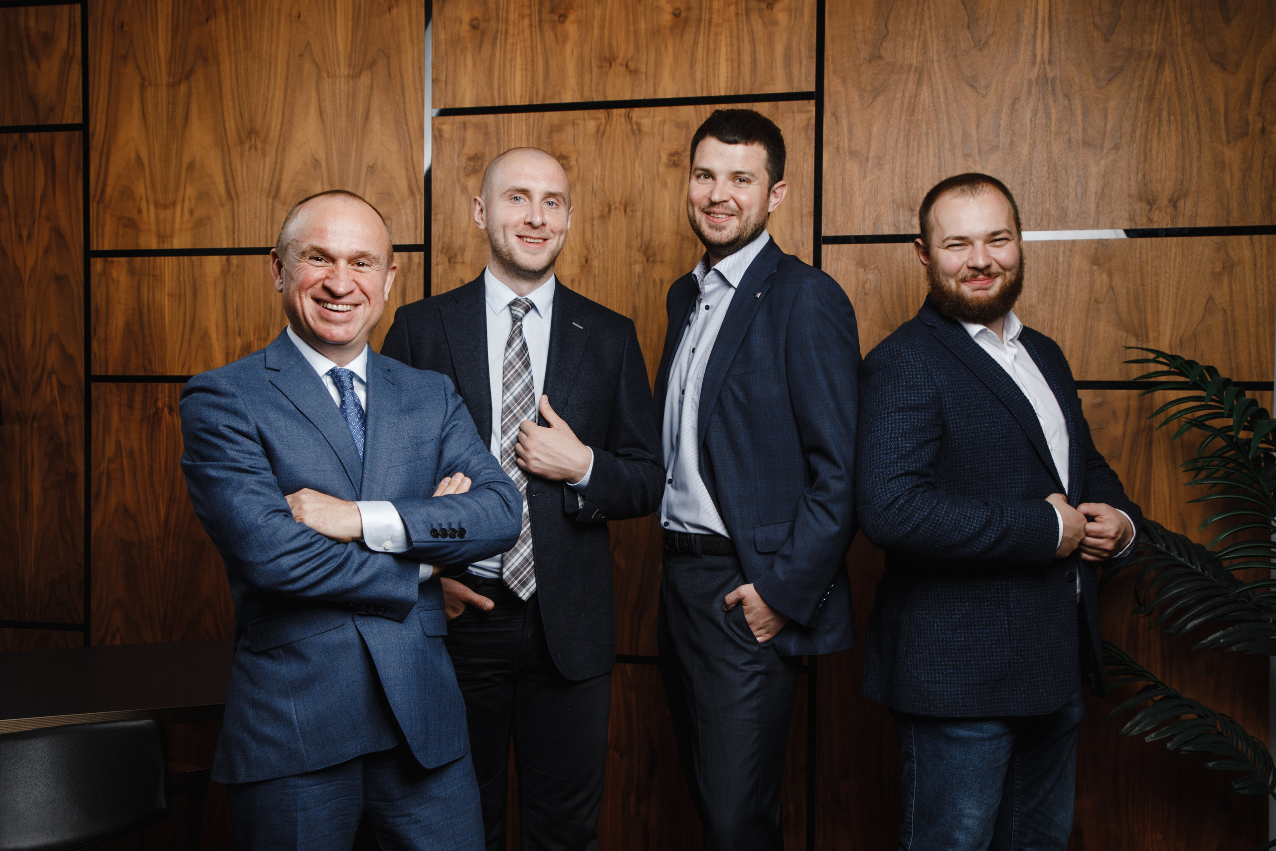 Групповой портрет четырех юристов на фактурном фоне в кабинете.