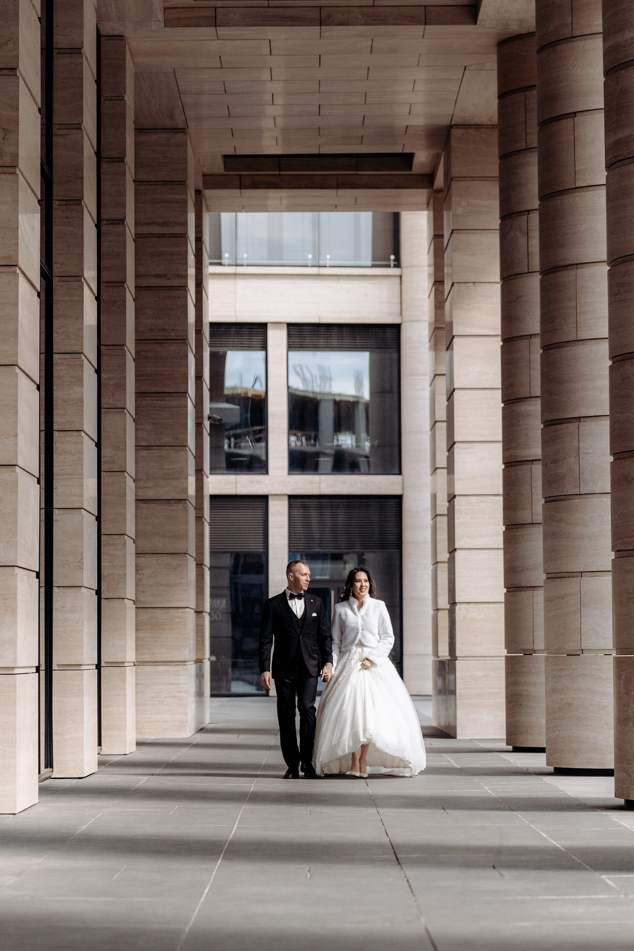 Свадебная фотосессия в Невской ратуше пара идет у колон