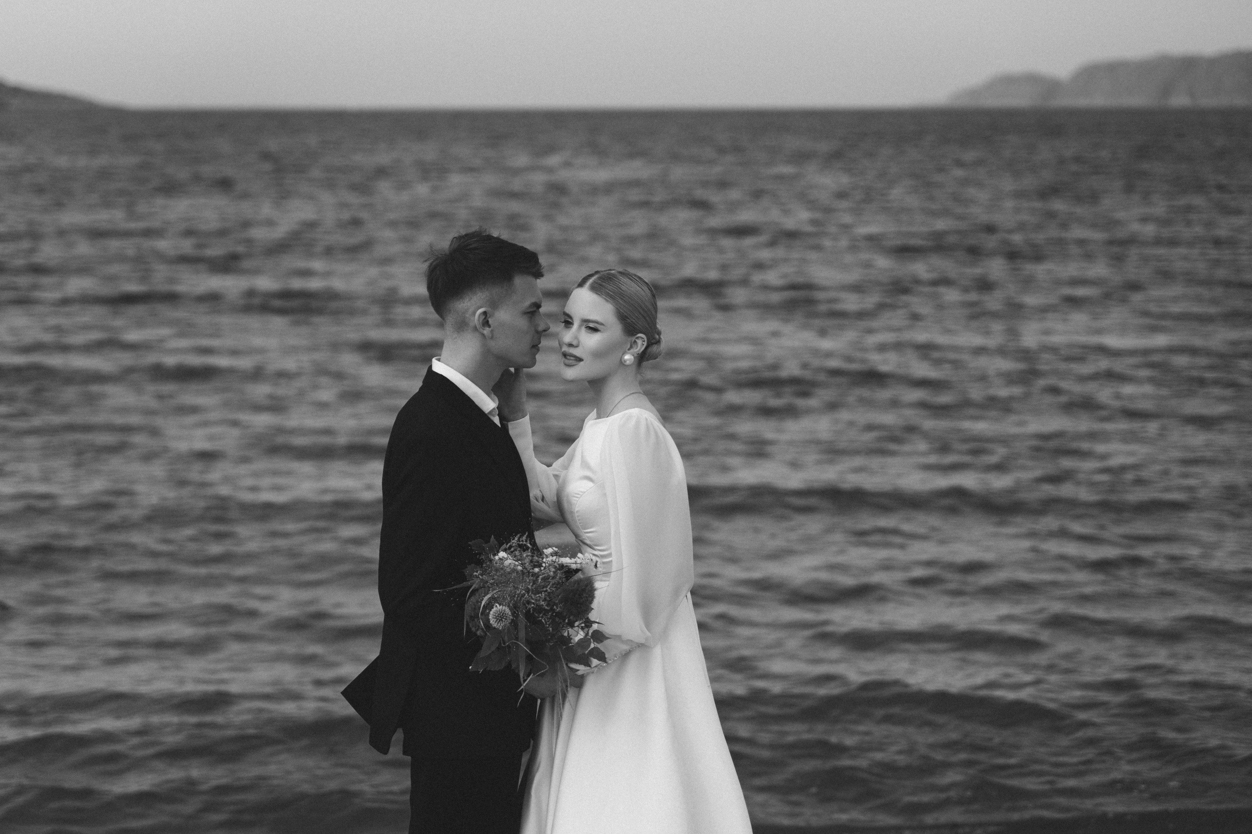 Красивый портрет молодой пары на фоне бескрайнего Баренцева моря.