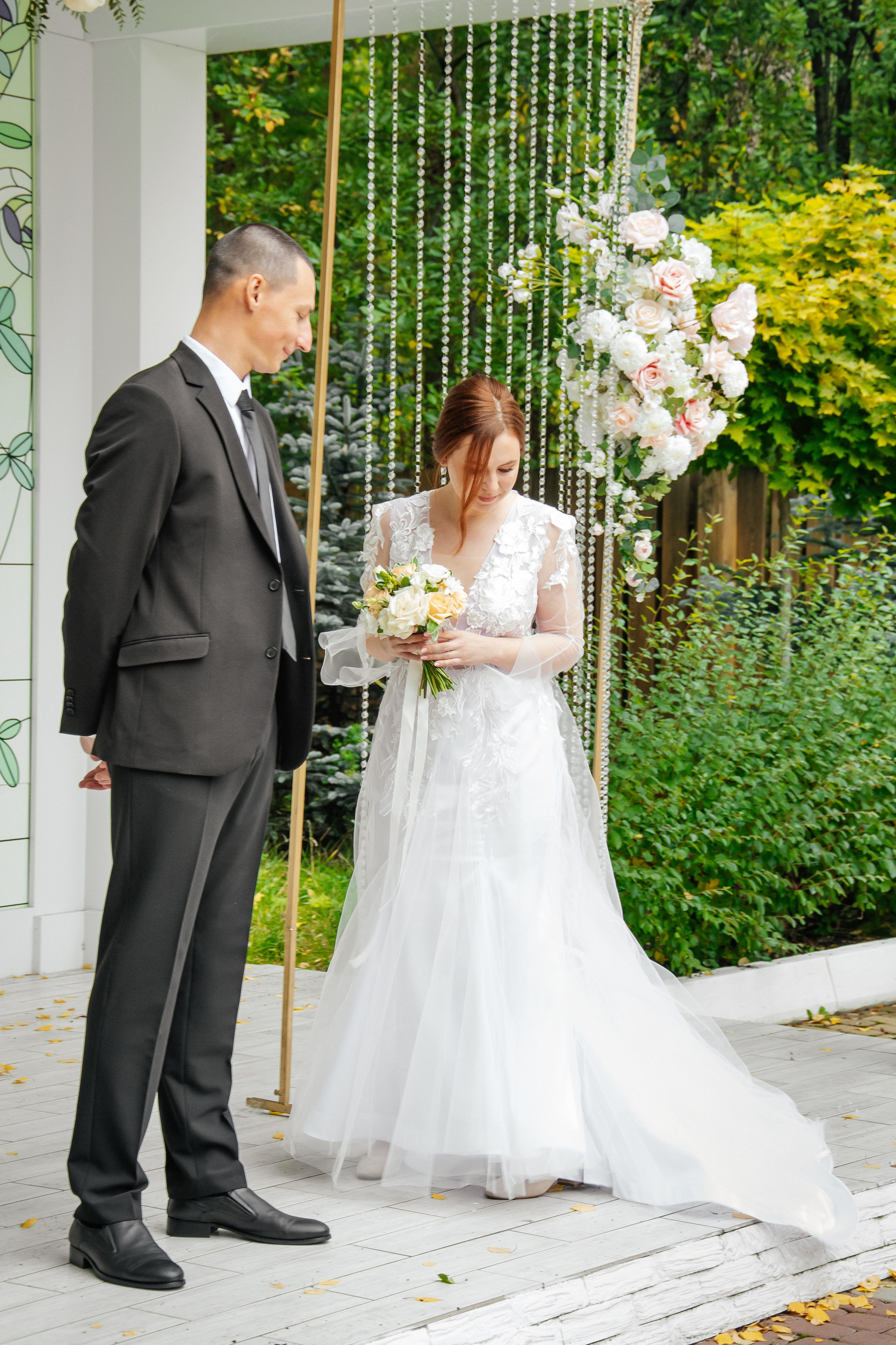 Жених и невеста на месте проведения свадебной церемонии перед гостями