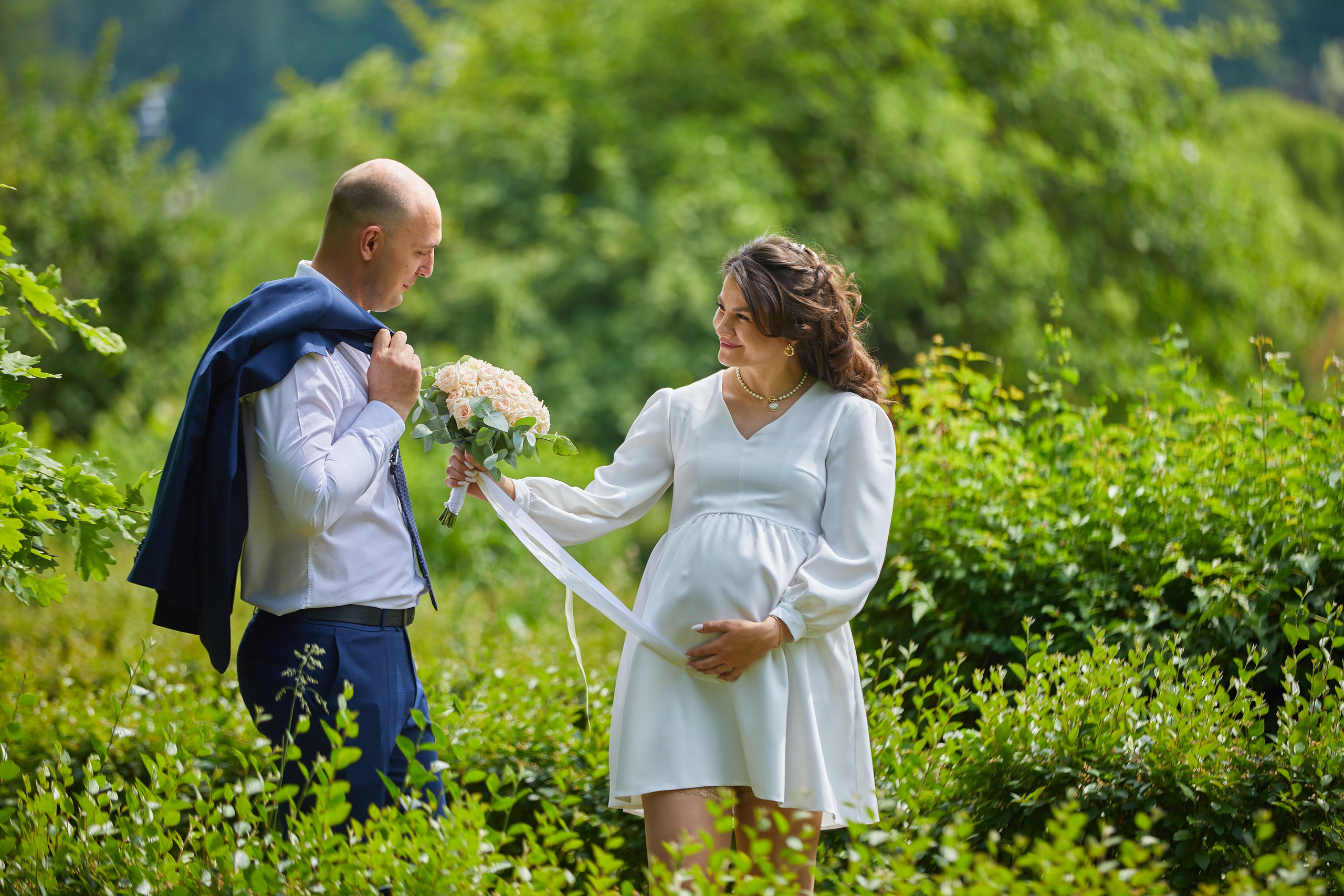 kogan.studio - жених и невеста прогуливаются по парку на фоне кустов