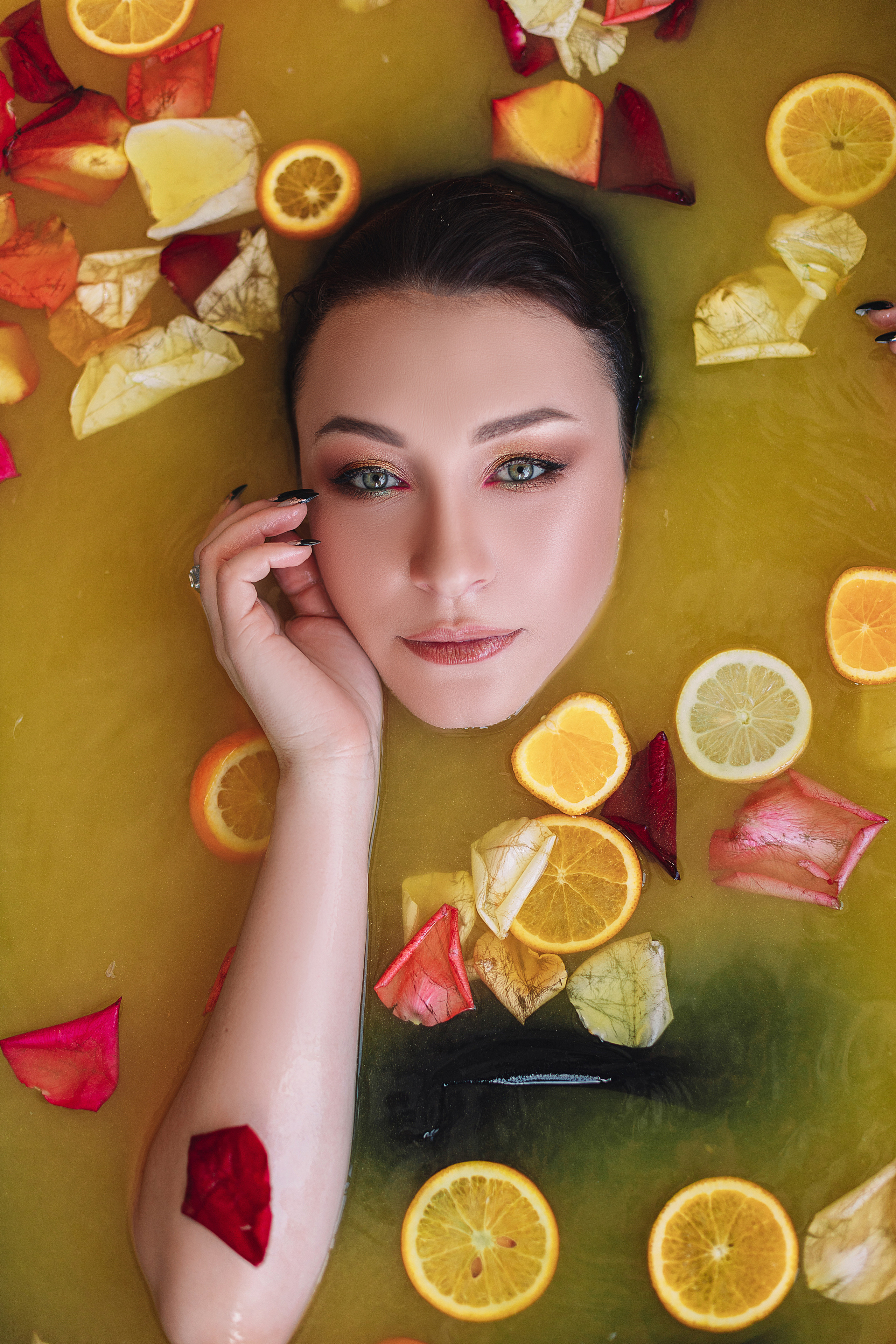 Нежная съёмка в ванной с апельсинами и цитрусами, лепестки роз.