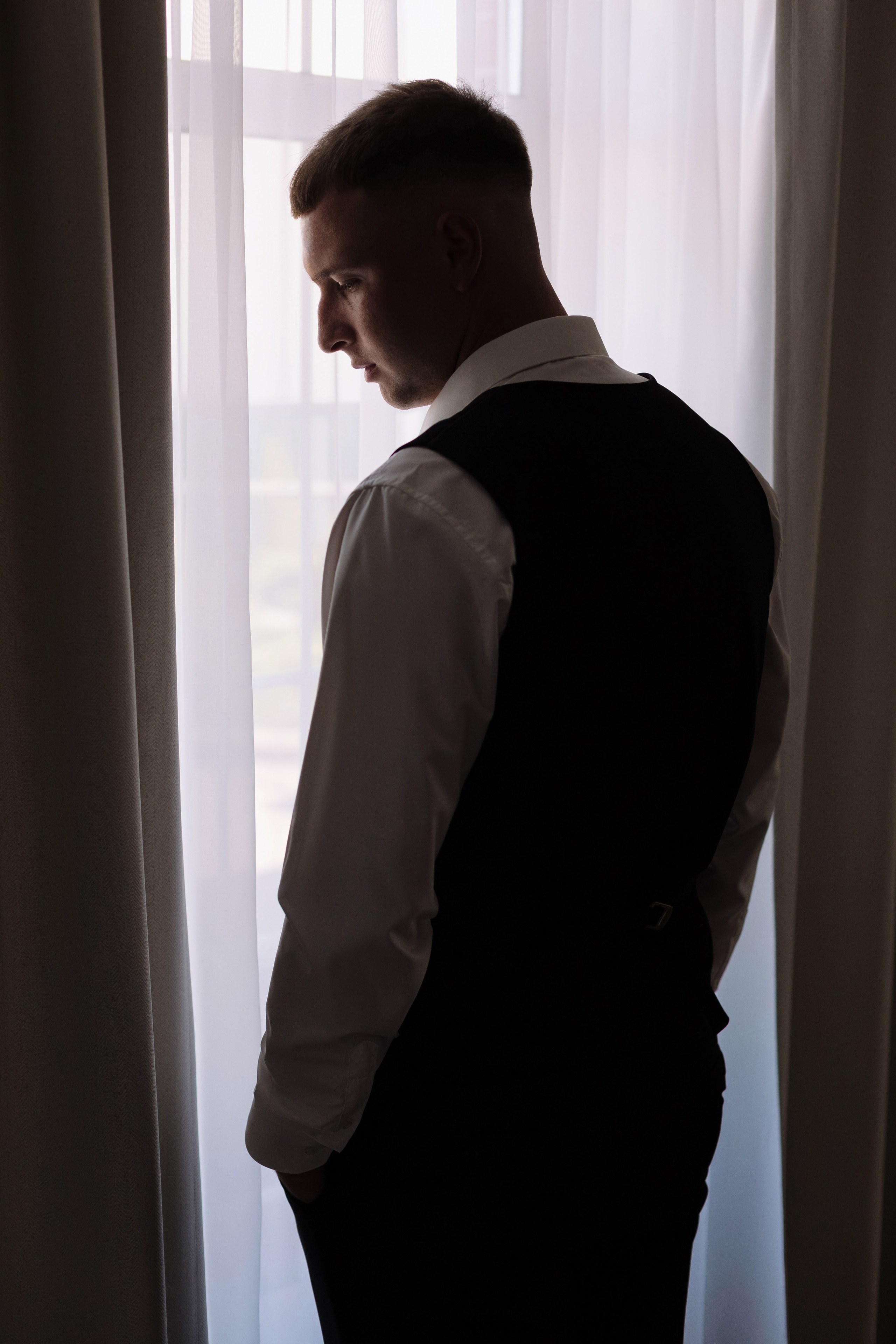 Портрет жениха у окна в номере отеля Golden Horse, Таганрог — свадебная фотосессия