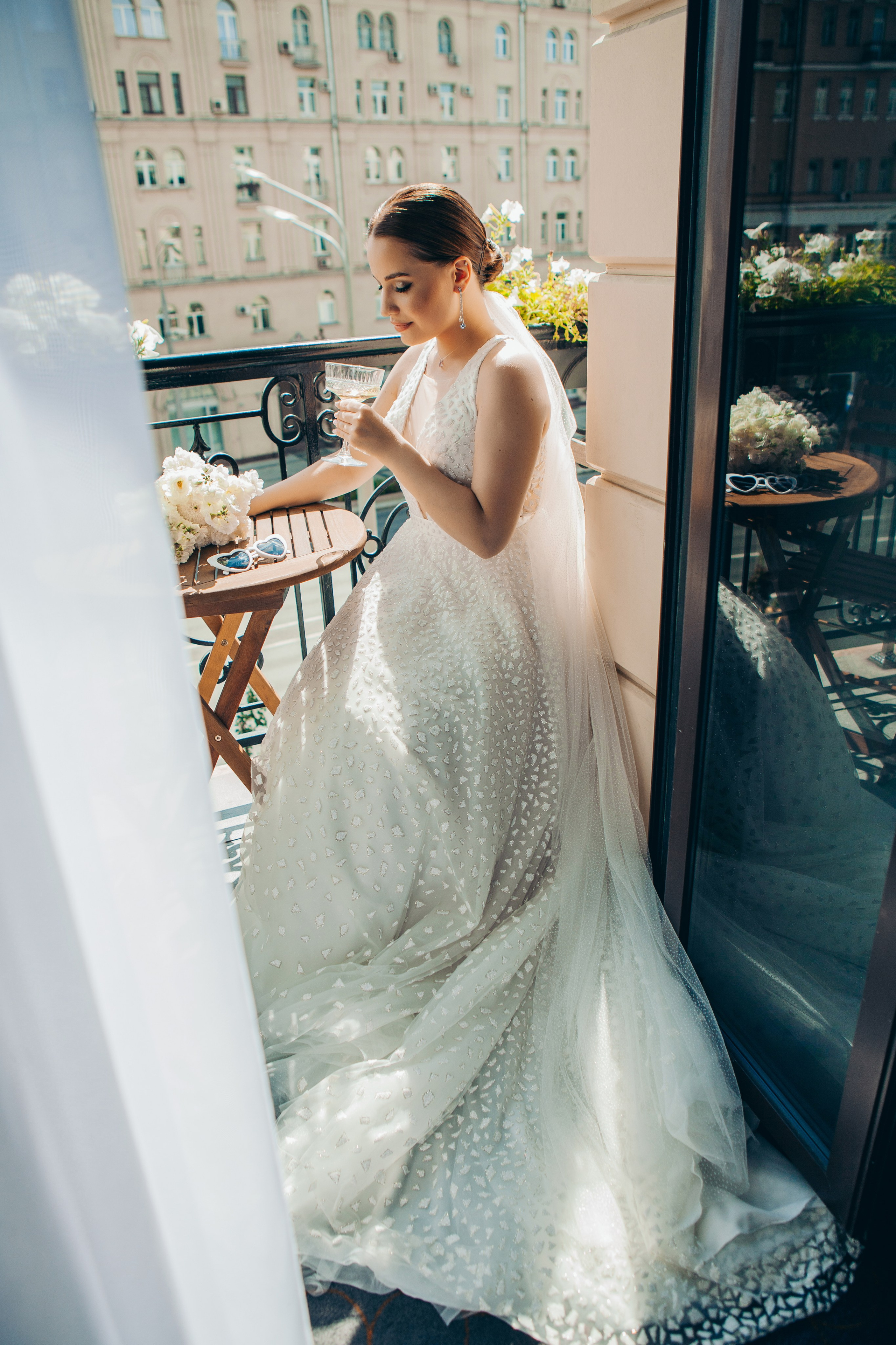 невеста сидит на балконе отеля Hartwell  и пьет шампанское 