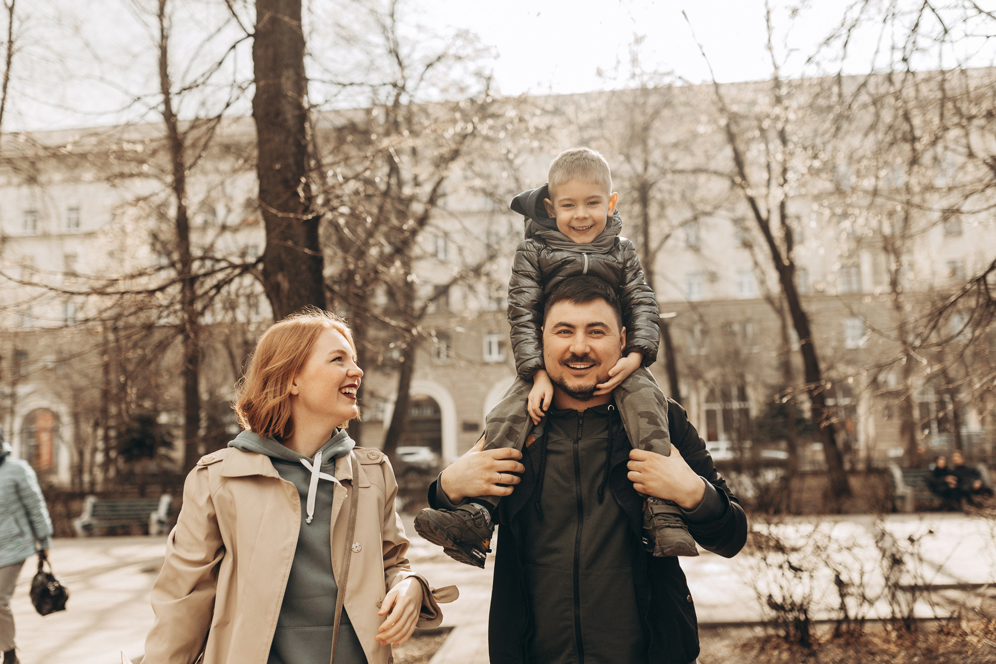 Прогулка по скверу в городе весной семья из трёх человек