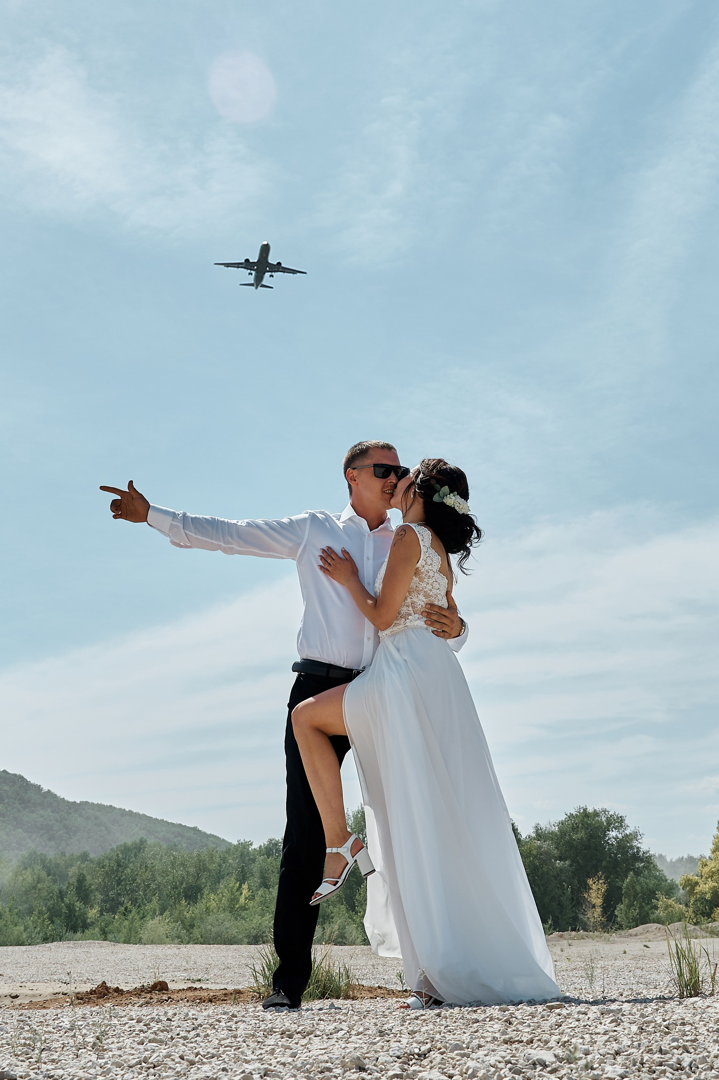 Жених и невеста целуются, а над ними летит самолет