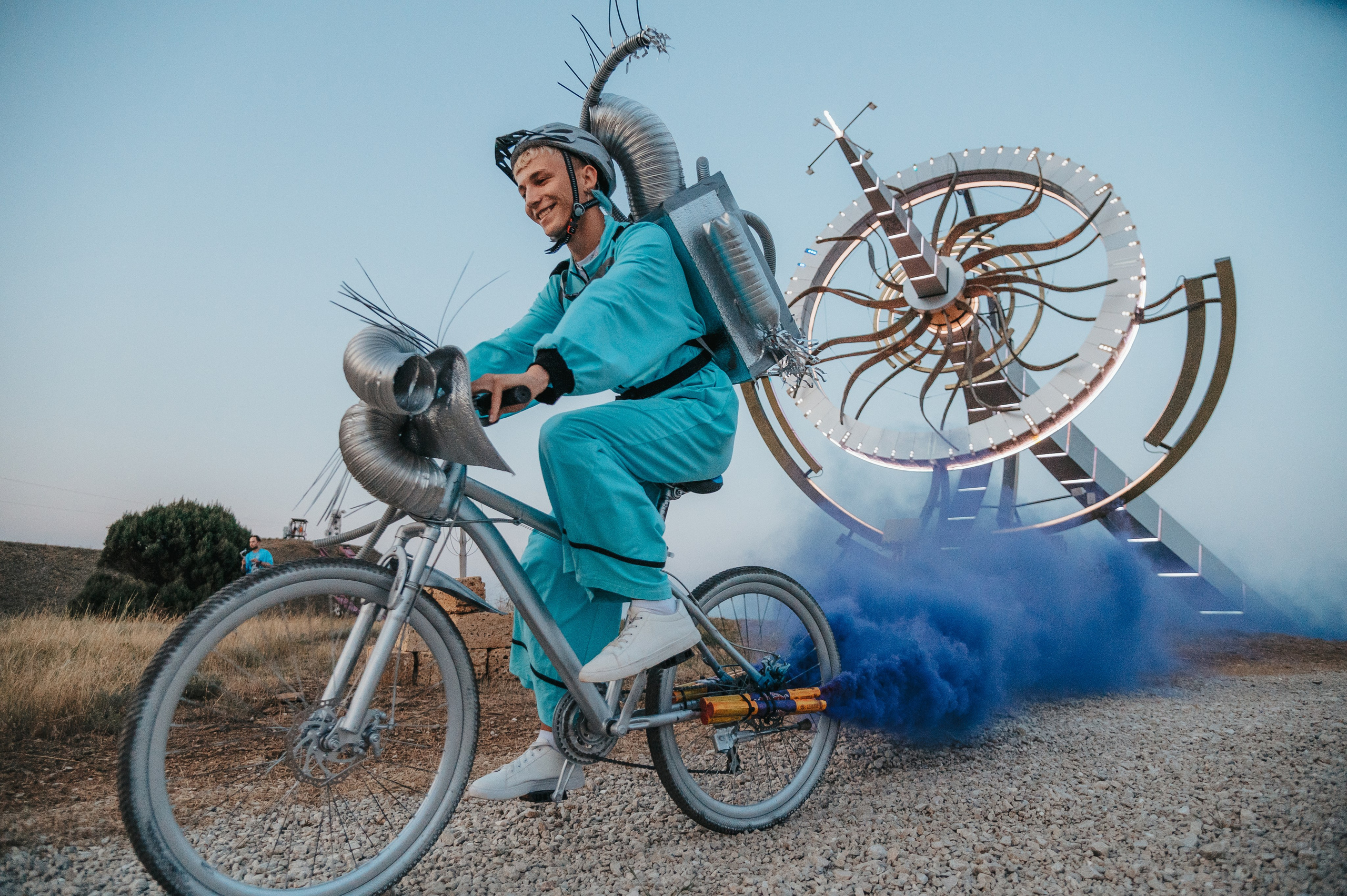 Репортажная съемка перфоменса велосипедиста в костюме с дымовыми шашками на велосипеде
