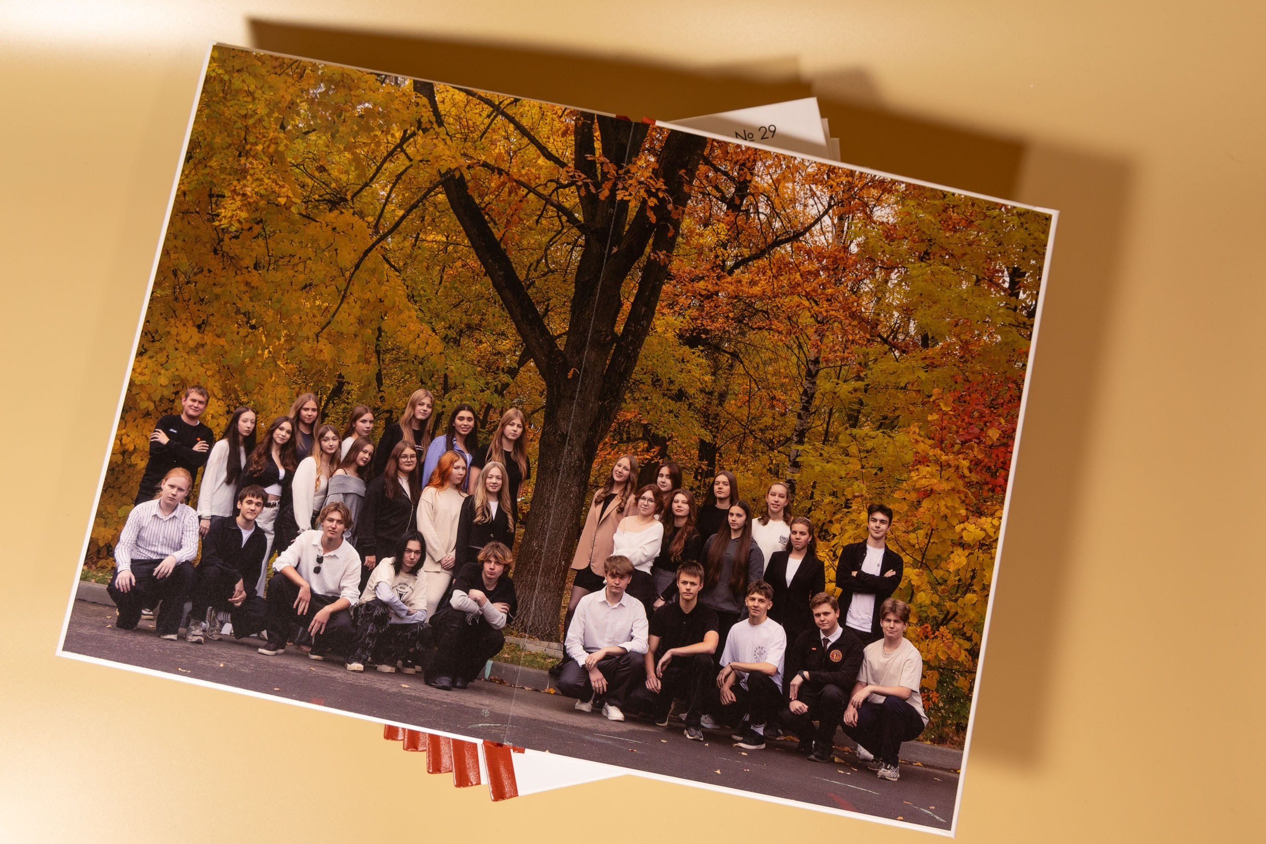 Разворот выпускной фотокниги с общей осенней фотографией.