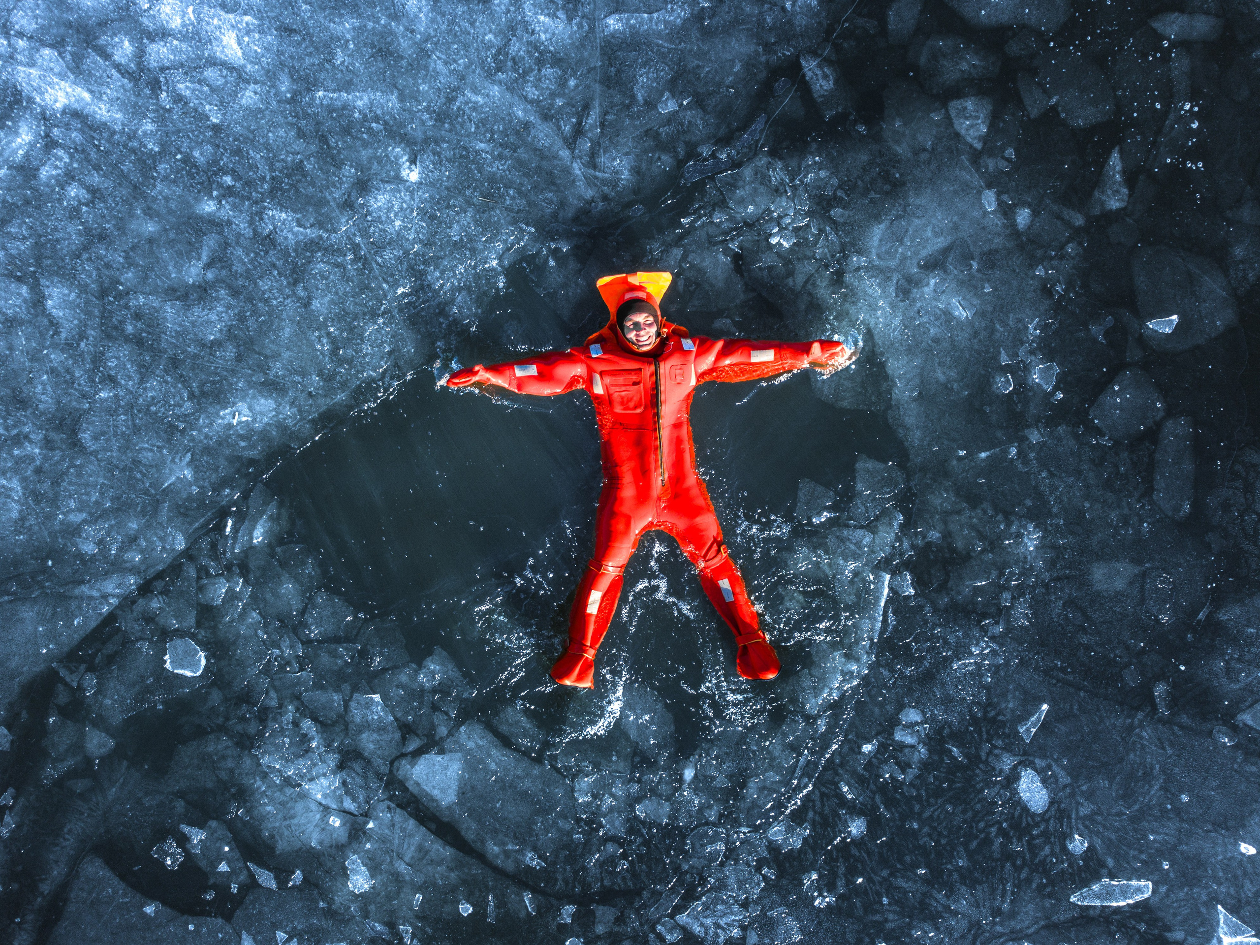 Люди купаются среди льдин, в спасательных оранжевых термо костюмах, айс флоатинг Ярославль