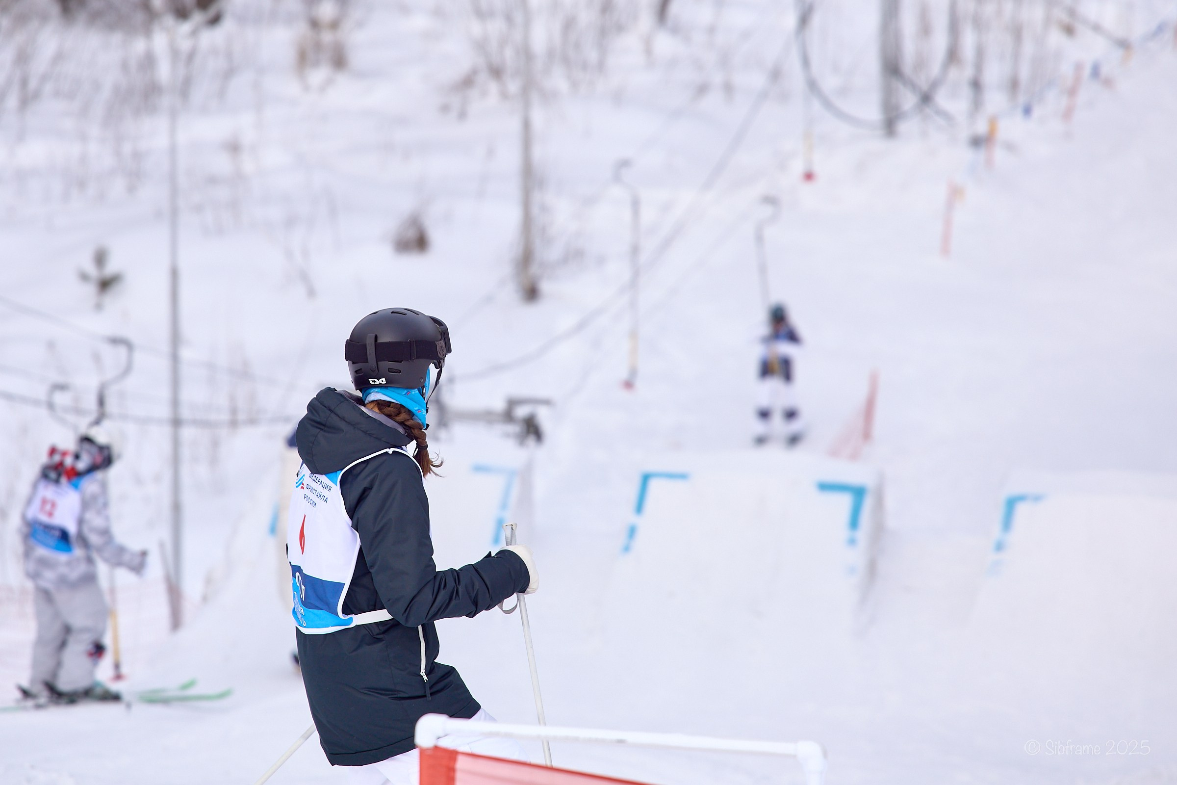 Спортсмен оценивает трамплин перед прыжком в дисциплине лыжный фристайл.