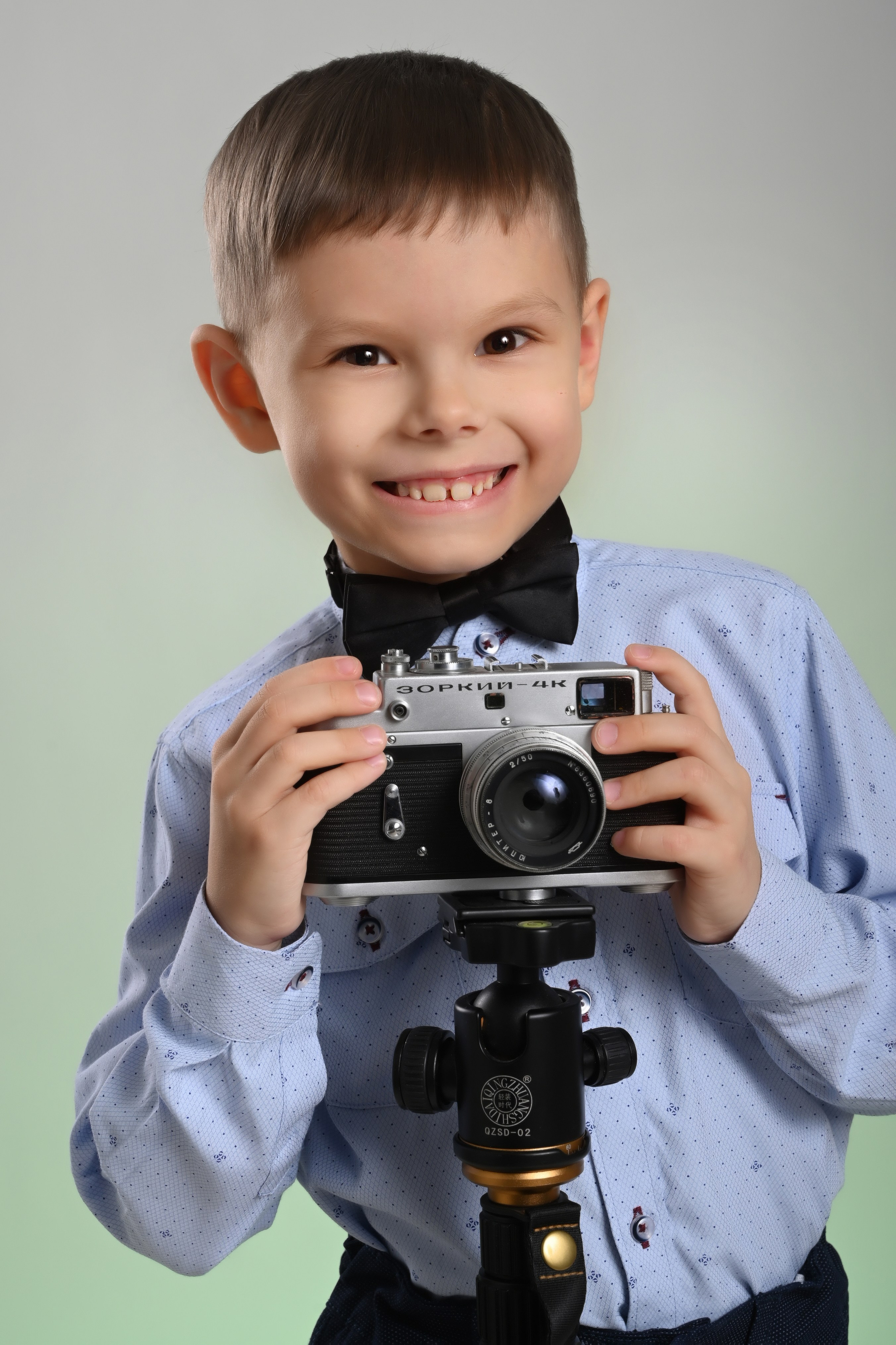 Мальчик выпускник детского сада в Вологде в голубой рубашке с камерой улыбается