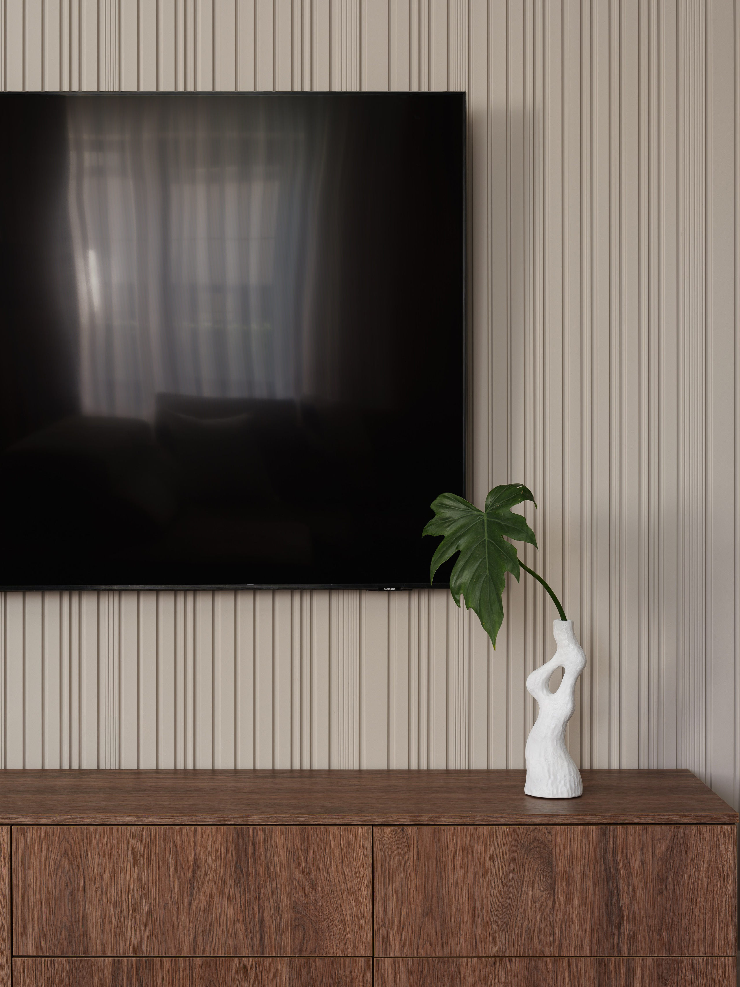 Фото современной ТВ-зоны в интерьере: минималистичная стена с декоративными рейками, деревянная тумба и стильный декор. Современный дизайн интерьера от Татьяны Диденко, фото Сергея Денисенко, стилистика Натальи Якушевой.