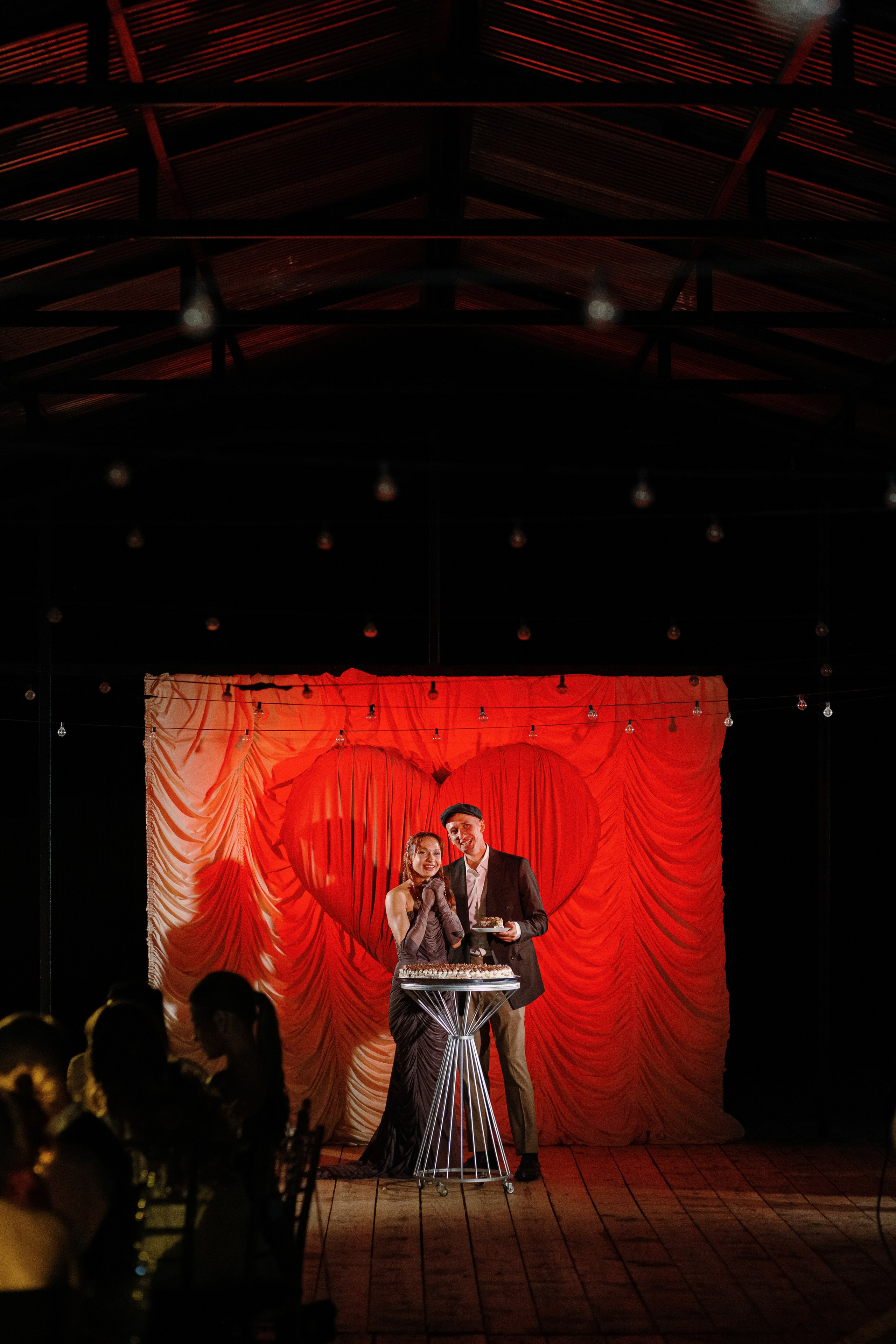 Свадебный фотограф Таганрог — Валентин и Алина на свадебном ужине у торта, декор с сердцем и тёплый вечерний свет