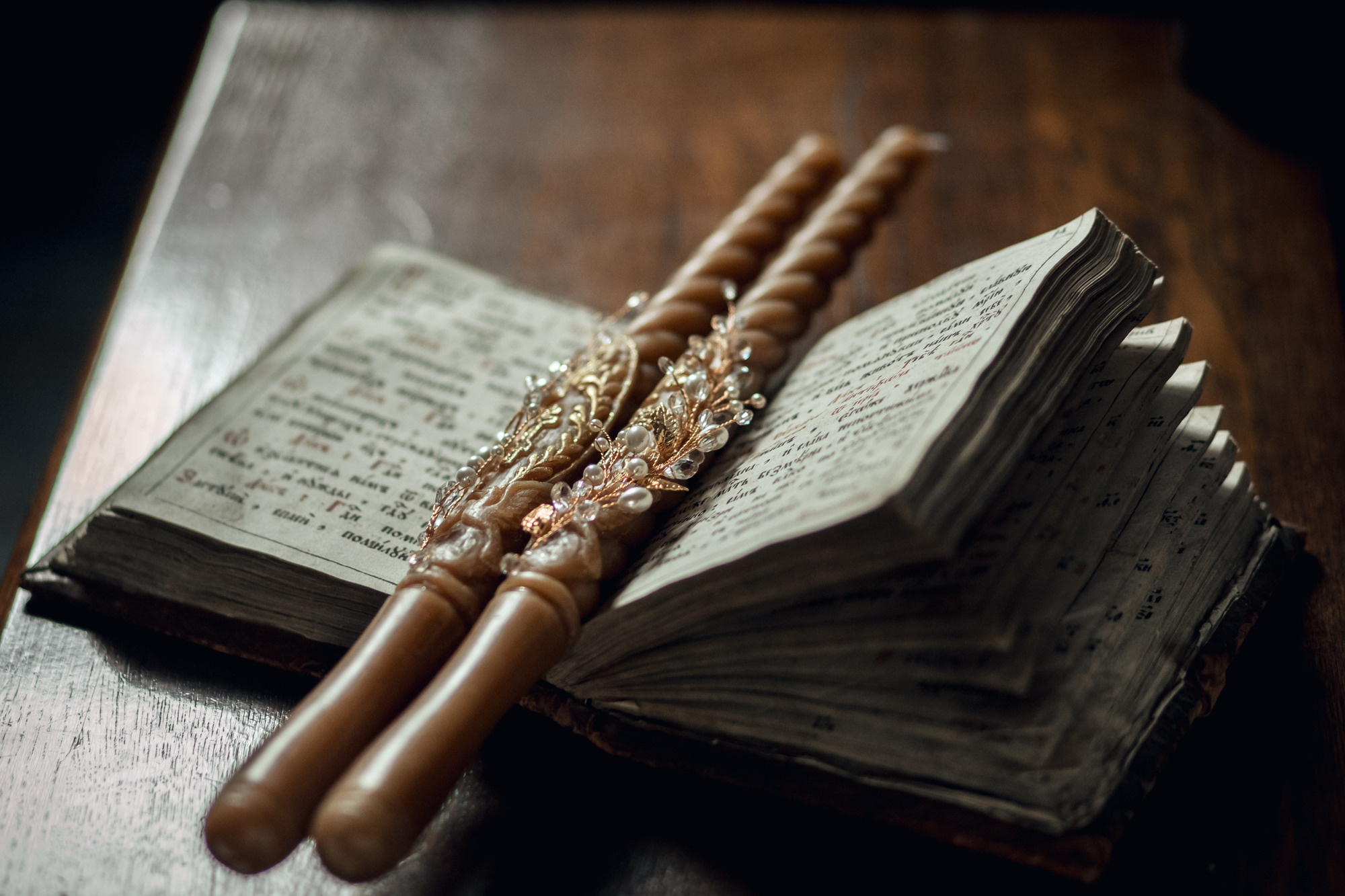 Свечи для венчания украшены бусинами , лежат на церковной книге