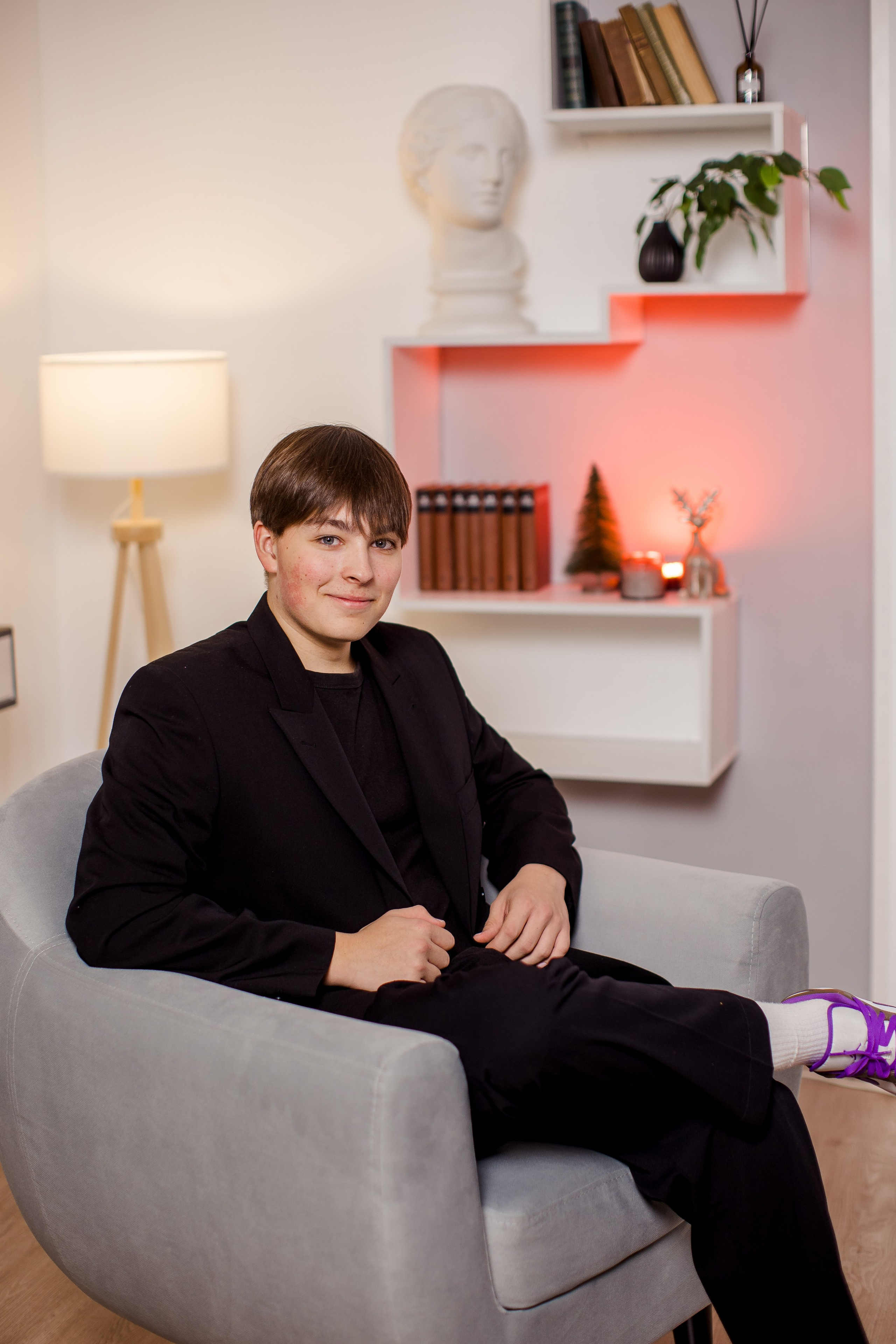 Портрет молодого человека в кресле в фотостудии