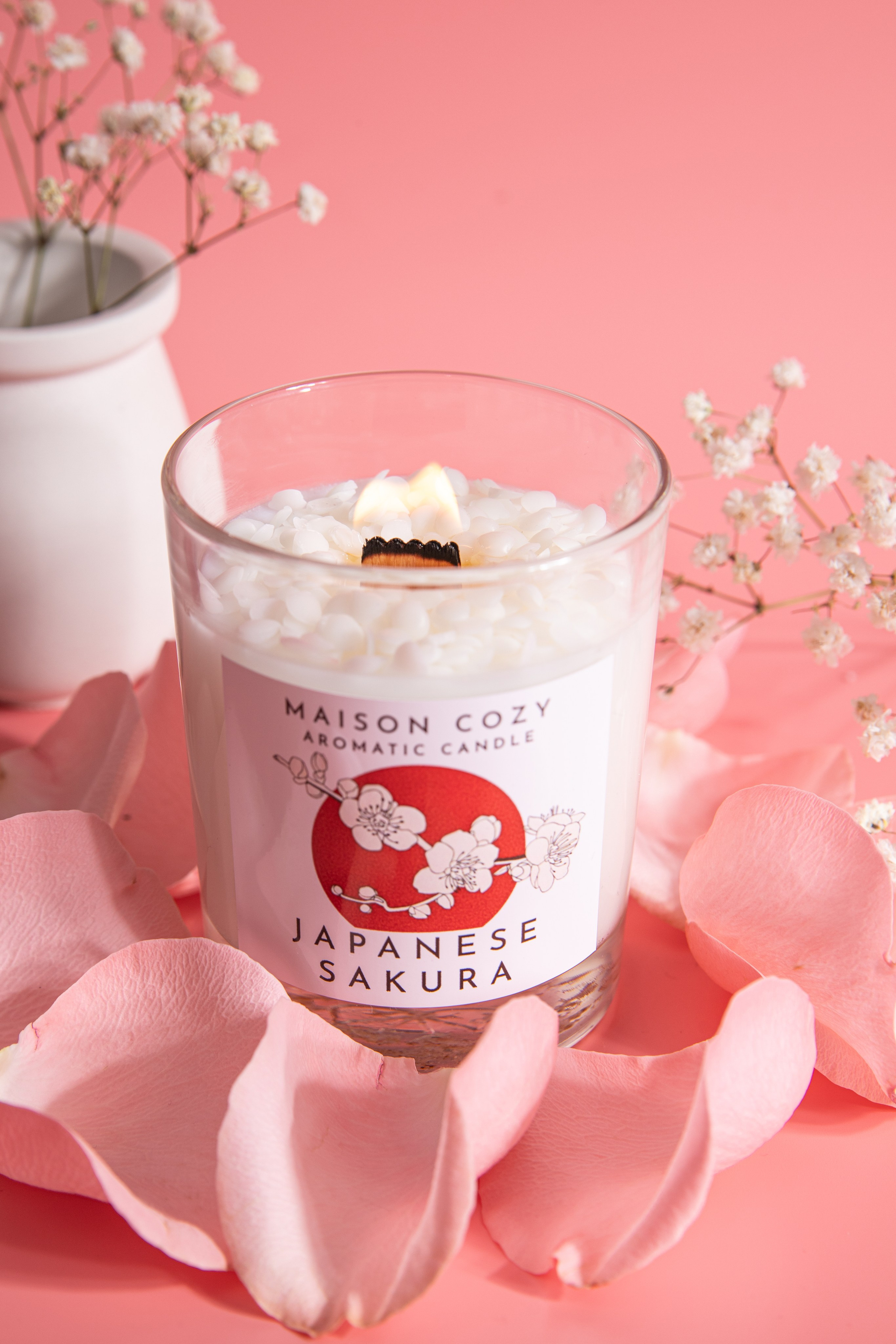 Ароматическая свеча с запахом цветущей сакуры в прозрачном стеклянном стакане, украшенном лепестками роз. Нежный розовый фон подчеркивает весеннюю эстетику. Натуральный соевый воск, деревянный фитиль и утонченный аромат японской вишни создают атмосферу гармонии и романтики. Идеально для медитации, оформления интерьера или в качестве элегантного подарка.