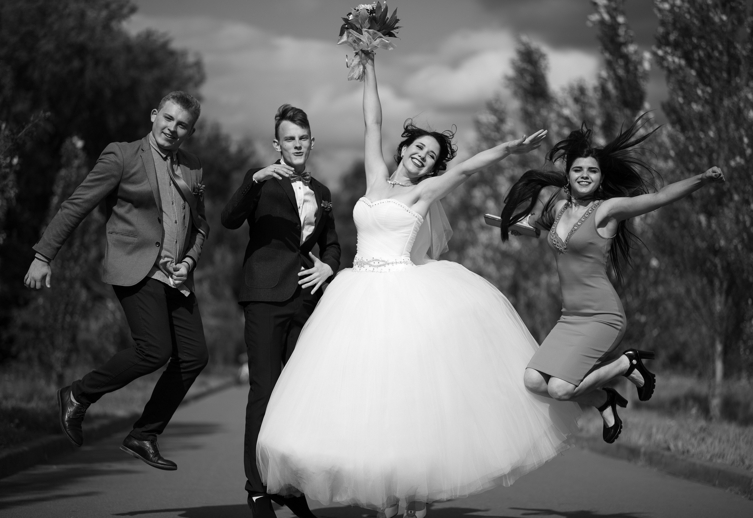 Жених, невеста и гости прыгают от счастья.