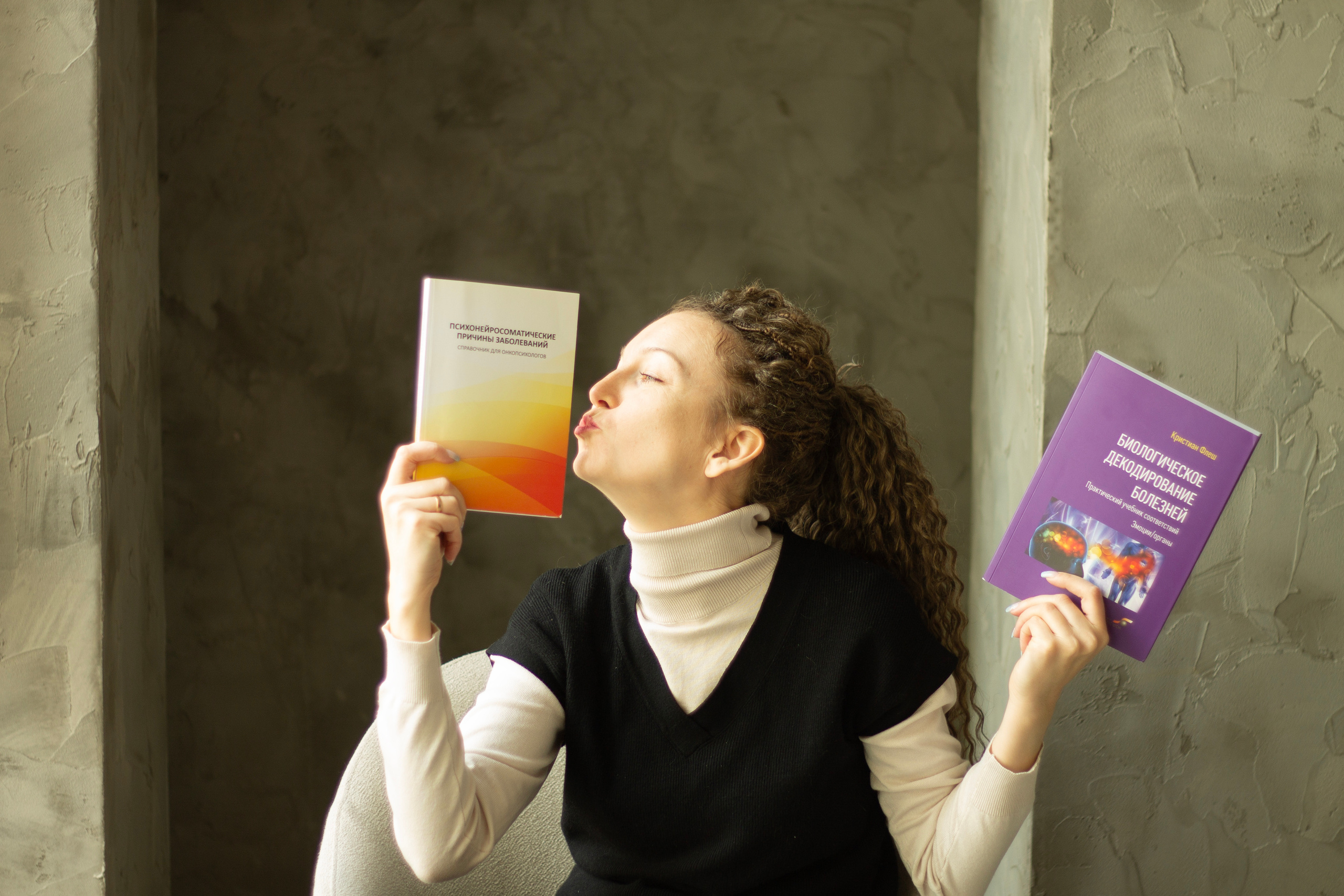 Девушка держит в руках книги целует одну из них