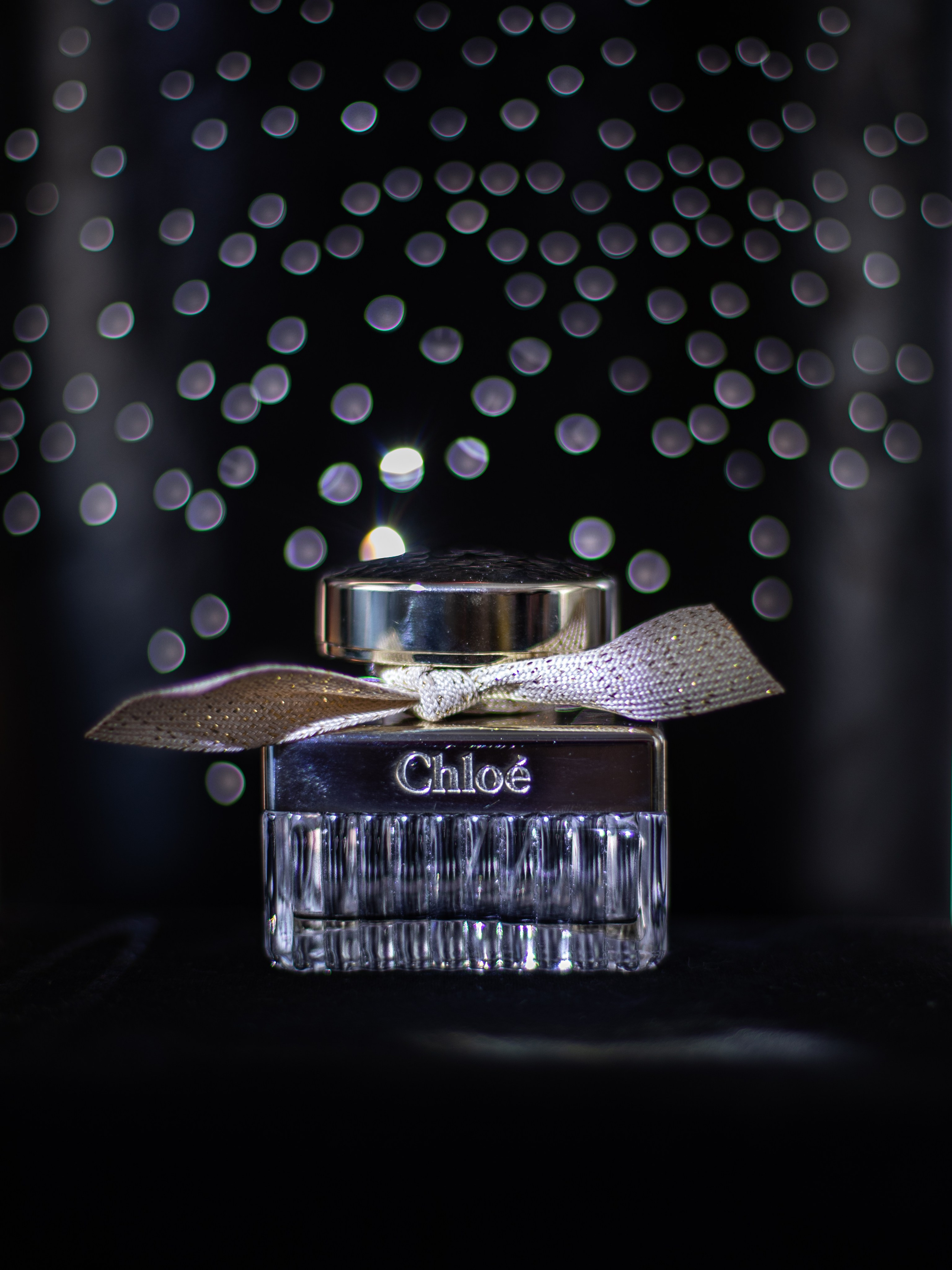 Флакон духов Chloe на черном фоне со звёздами 