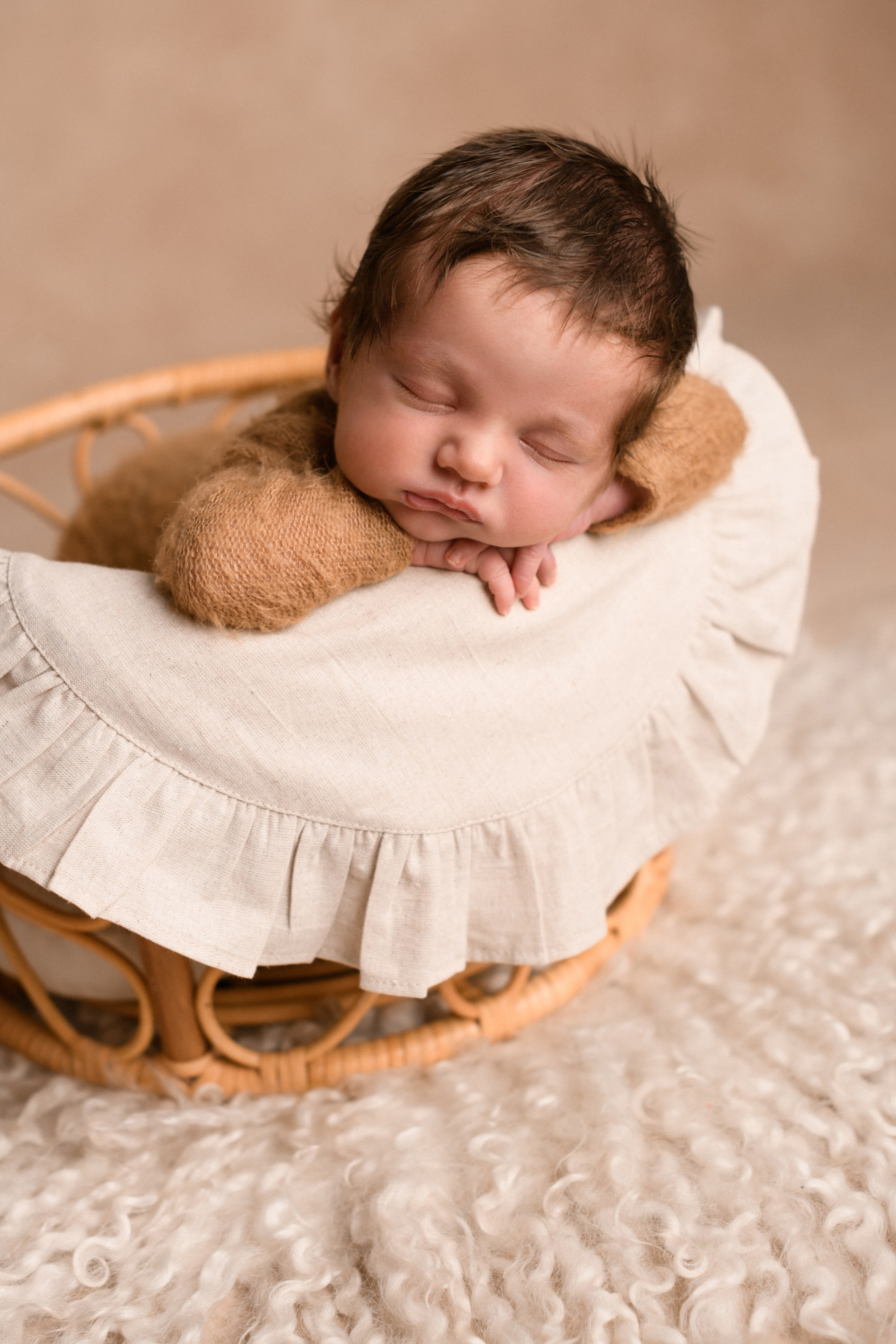Новорожденный малыш уютно лежит в корзиночке в детской фотостудии "В капусте" фотографа новорожденных Алёны Лариной в Липецке