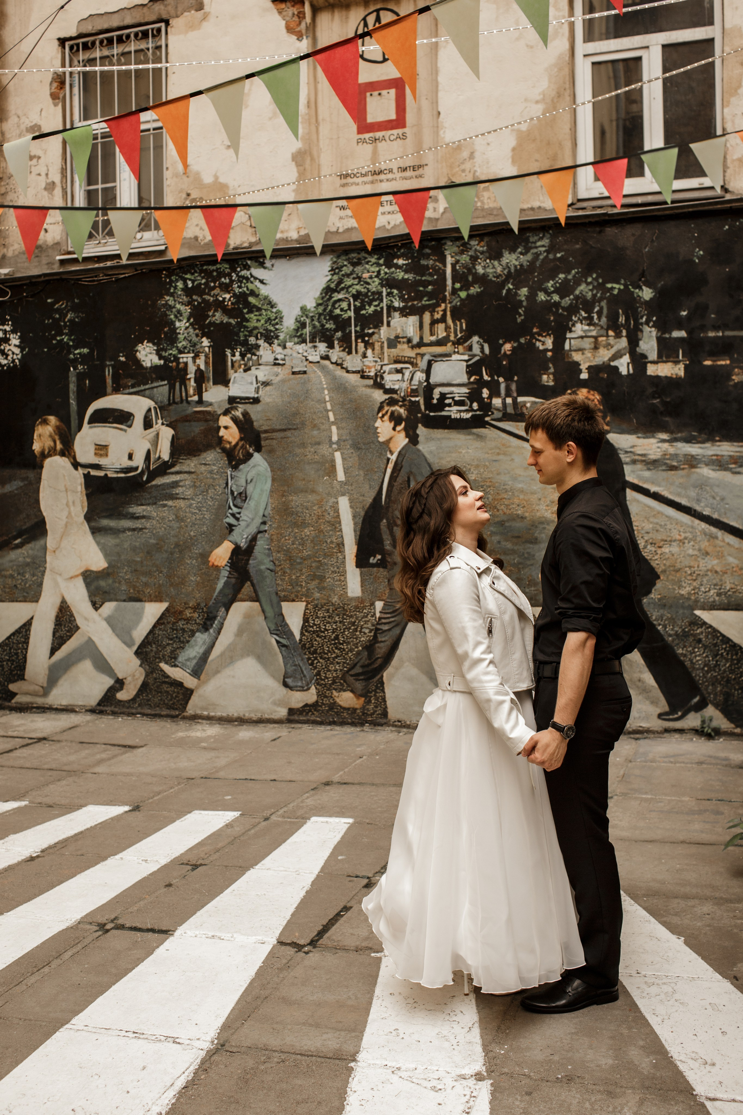 Свадебная фотография в стиле рок; молодожены на фоне группы Битлз.