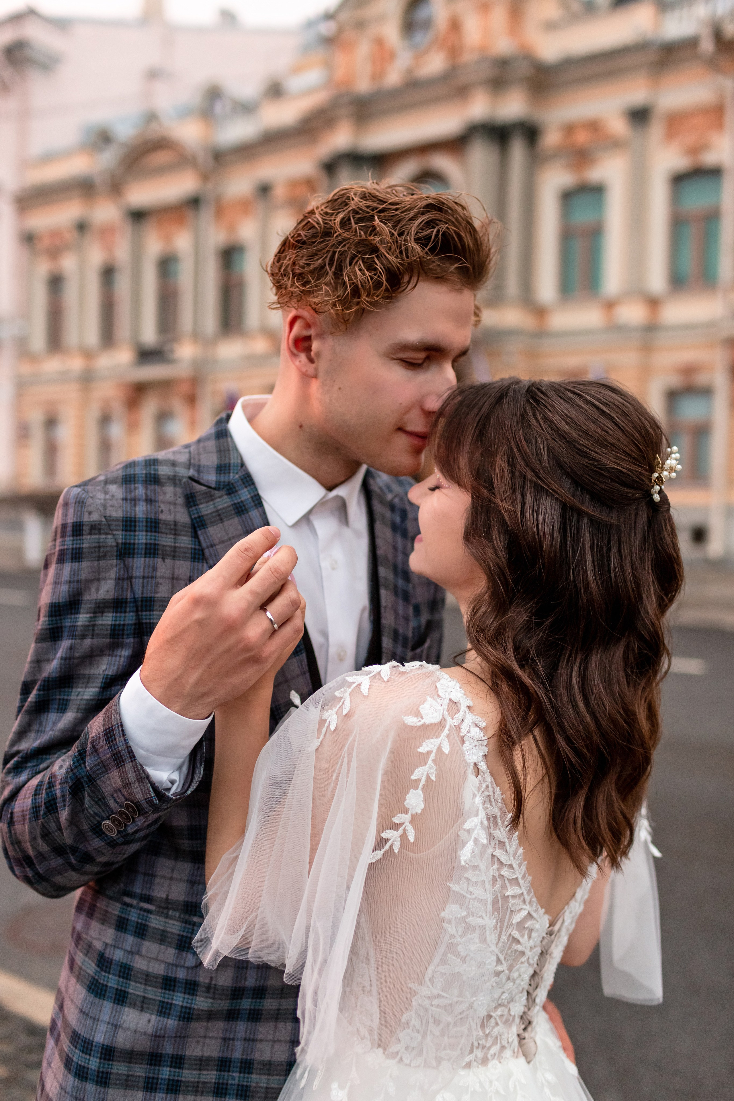 Жених и невеста на фоне городского фасада